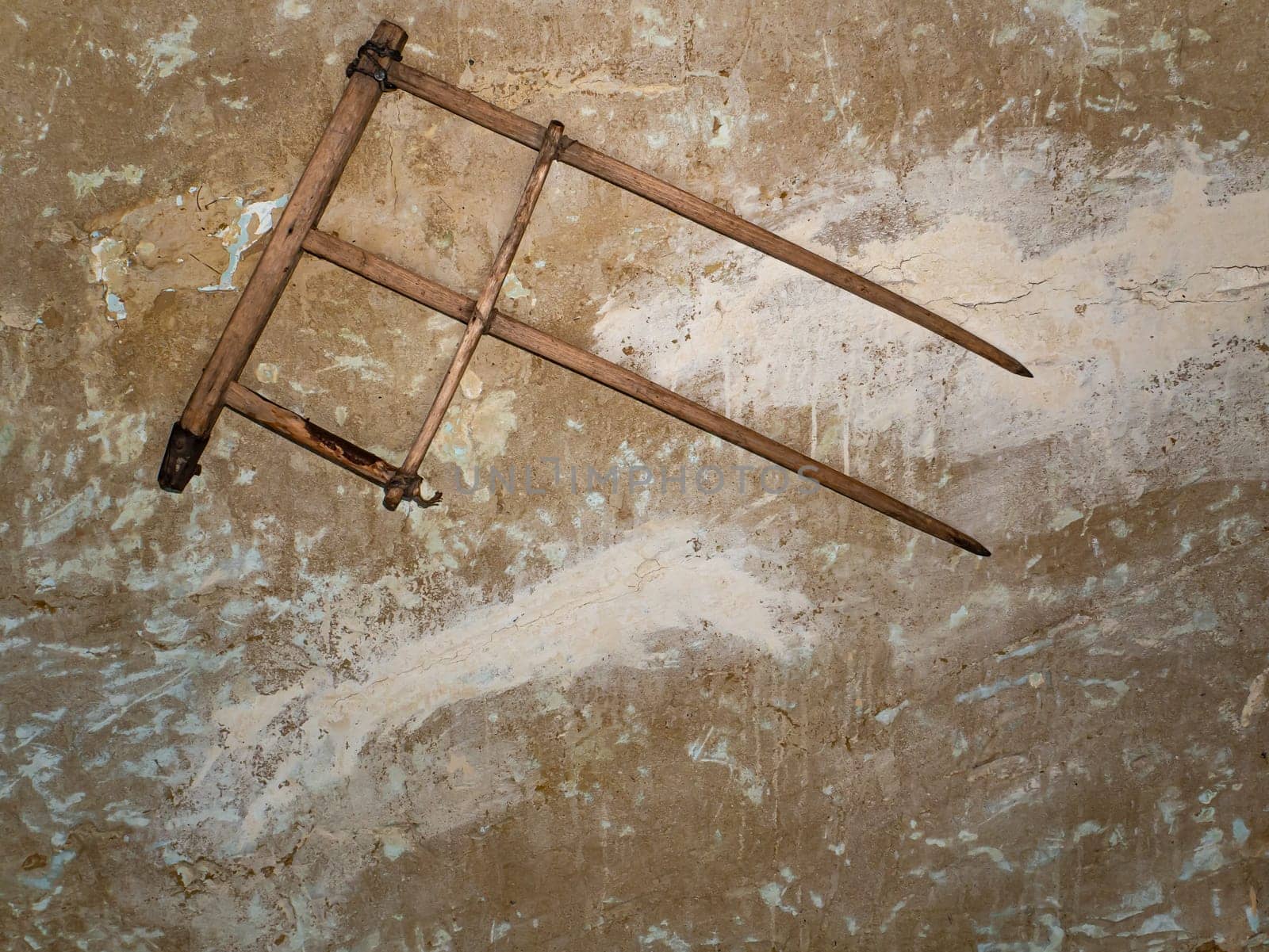 An old wooden head for a hand scythe. Wooden retro tool. Retro room interior. Old-fashioned background. Background image. Place for text.