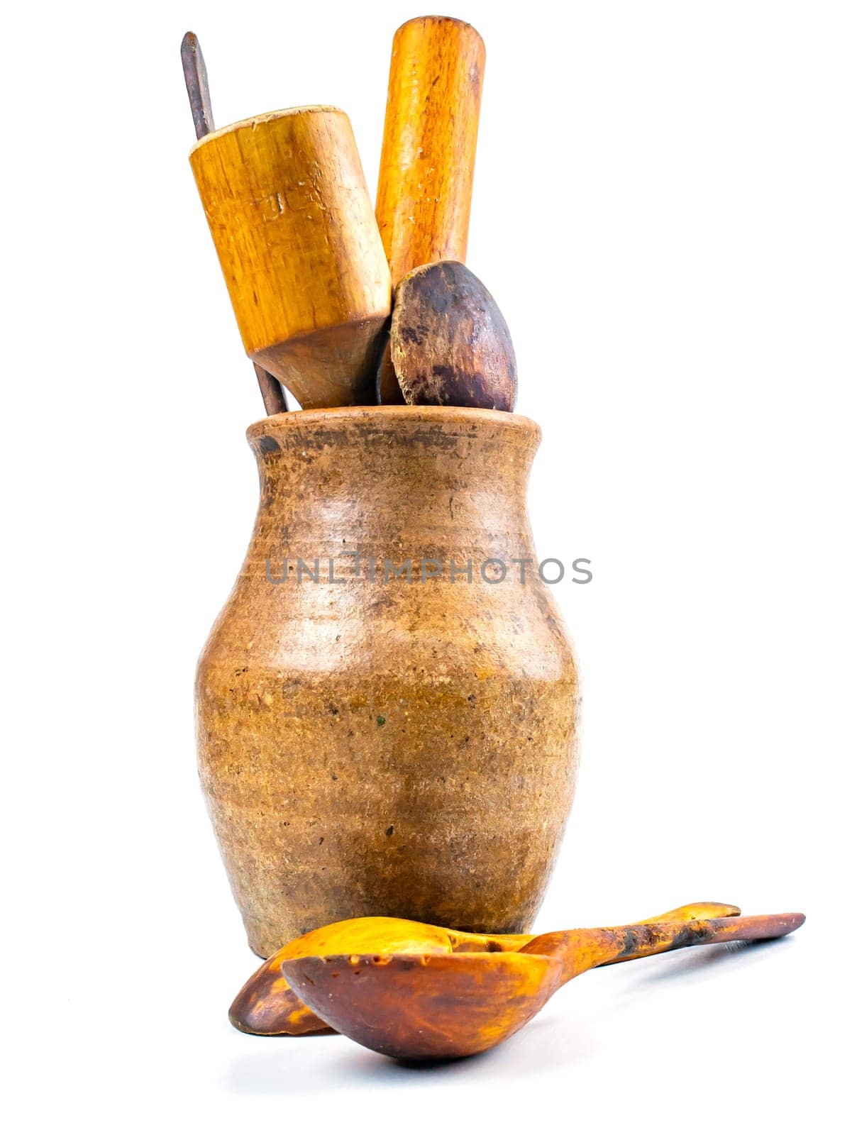 Ceramic clay jug with wooden kitchen utensils. Old kitchen utensils. Handmade clay jug. Wooden kitchen spoons. White background. Background image. Place for text.