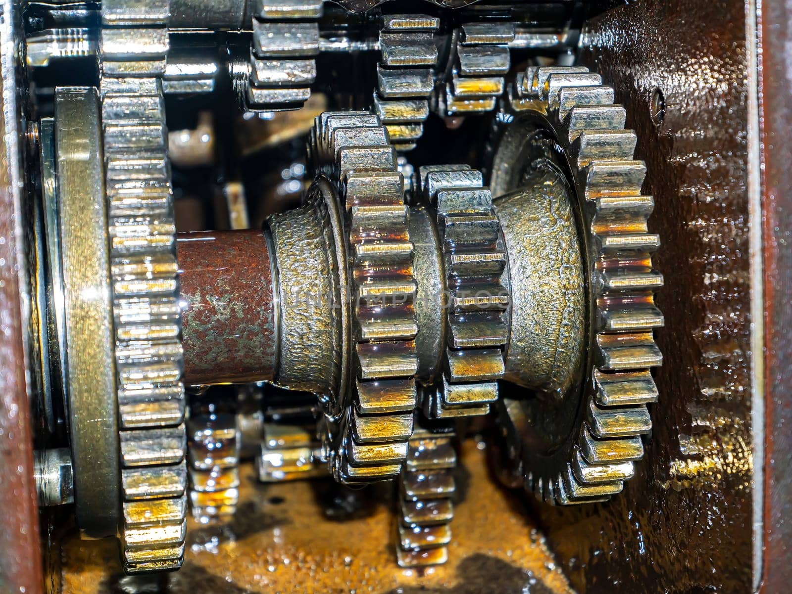 Gears of the rotating shaft of the vehicle. Car gears. Engine. Car repair. Mechanism lubricating oil. Agricultural tractor. Freight transport. Motoblock. Gearbox. Rotating part. Background.
