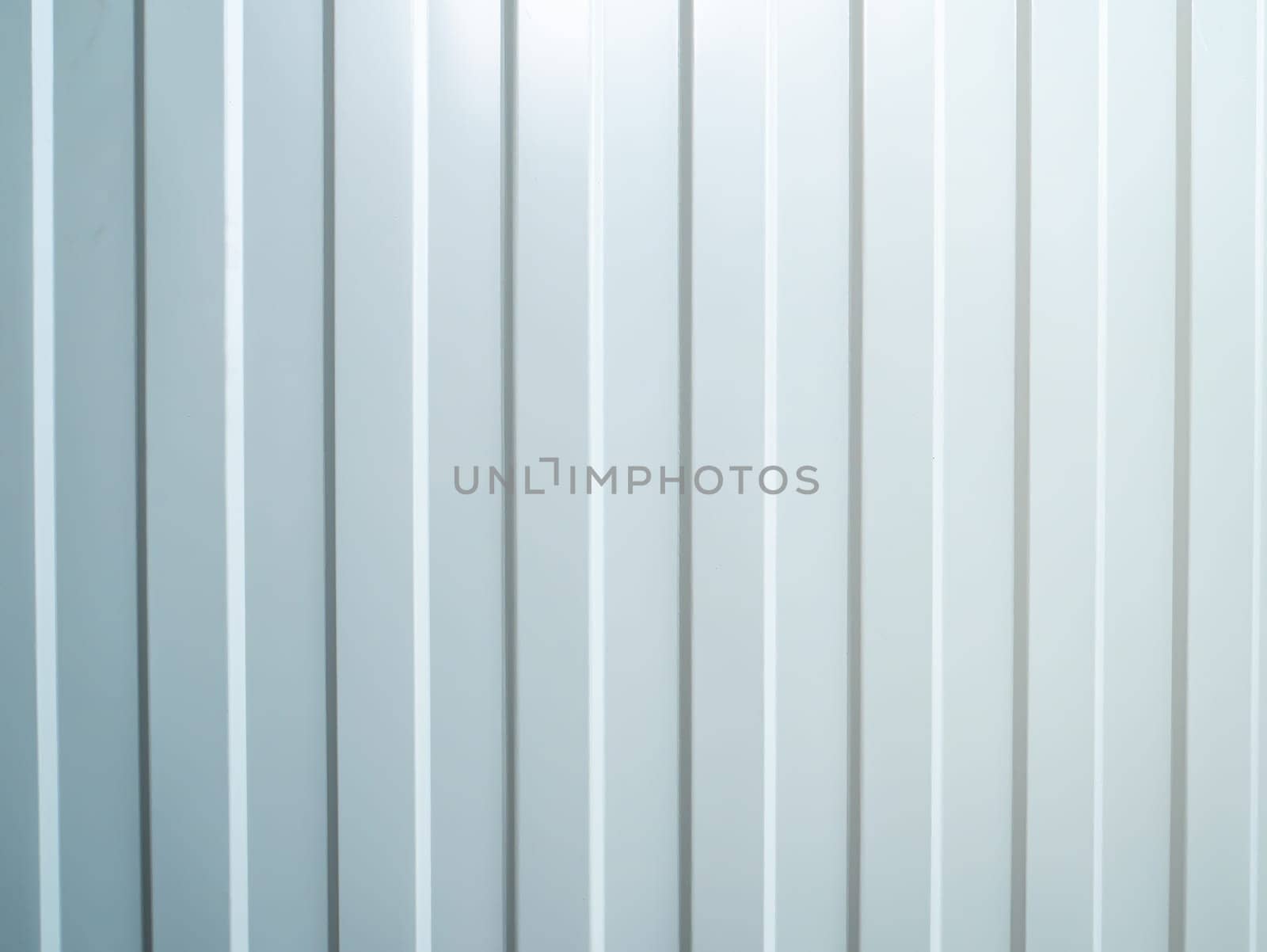 The texture of the striped corrugated metal surface is white. Vertical white stripes. The metal wall is painted white. Background image. Surface texture. Shadows. Place for your text. Poster.
