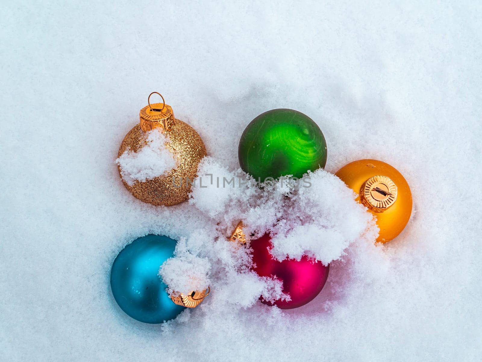 Christmas tree toys colored balls on white snow. Christmas holidays. New Year. Loose winter snow. New Year holidays. Winter vacation. White background. Place for text. Greeting card. Invitation.