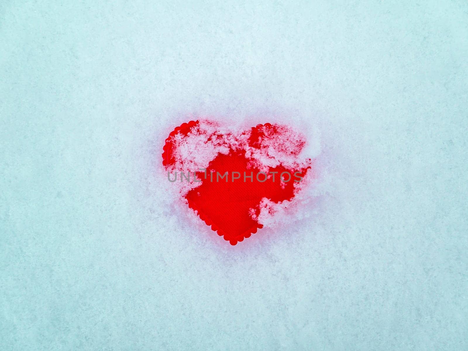 Valentine red heart symbol on white snow. Valentine's Day. Red valentine. Heart symbol. Day of Love. Feast in February. Valentine's day holiday. Fate. Engagement. Wedding. Greeting card.