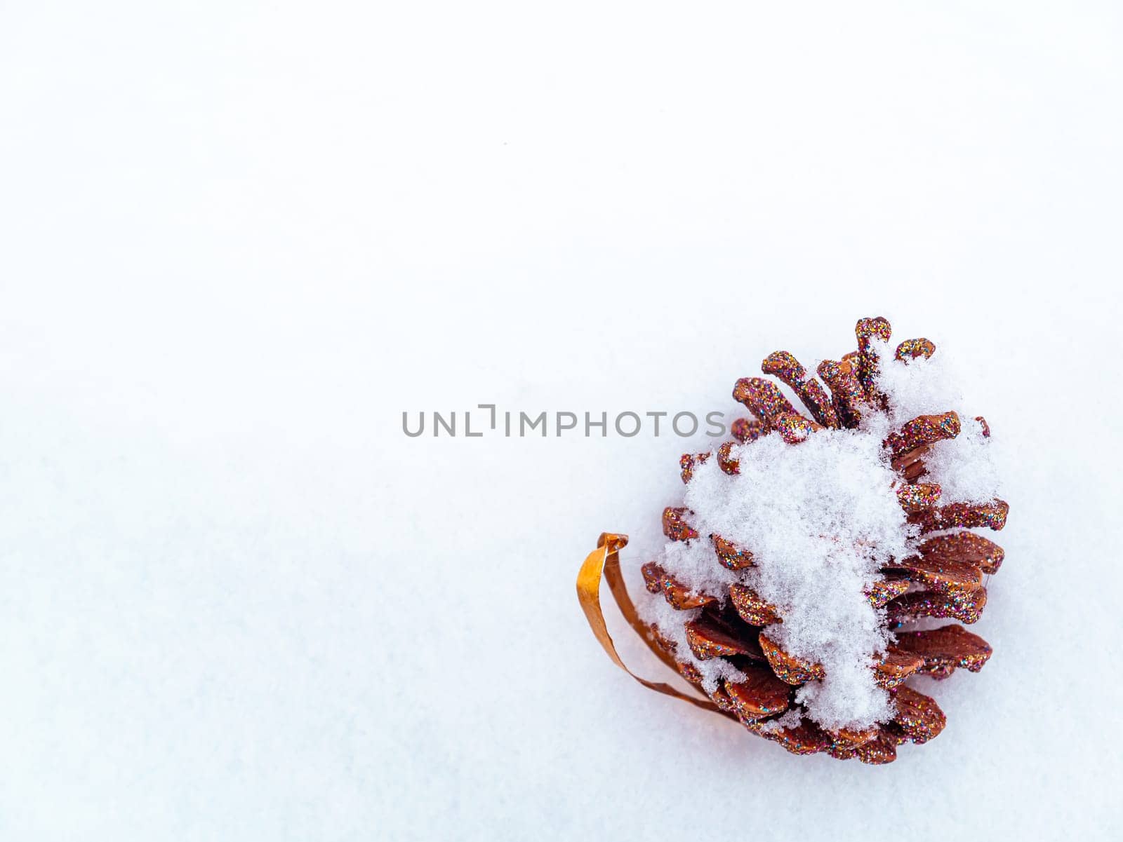 Christmas toy pine cone spruce on white snow. Pine cone. Christmas holidays. New Year. Loose winter snow. New Year holidays. Winter vacation. Place for text. Greeting card. White background.