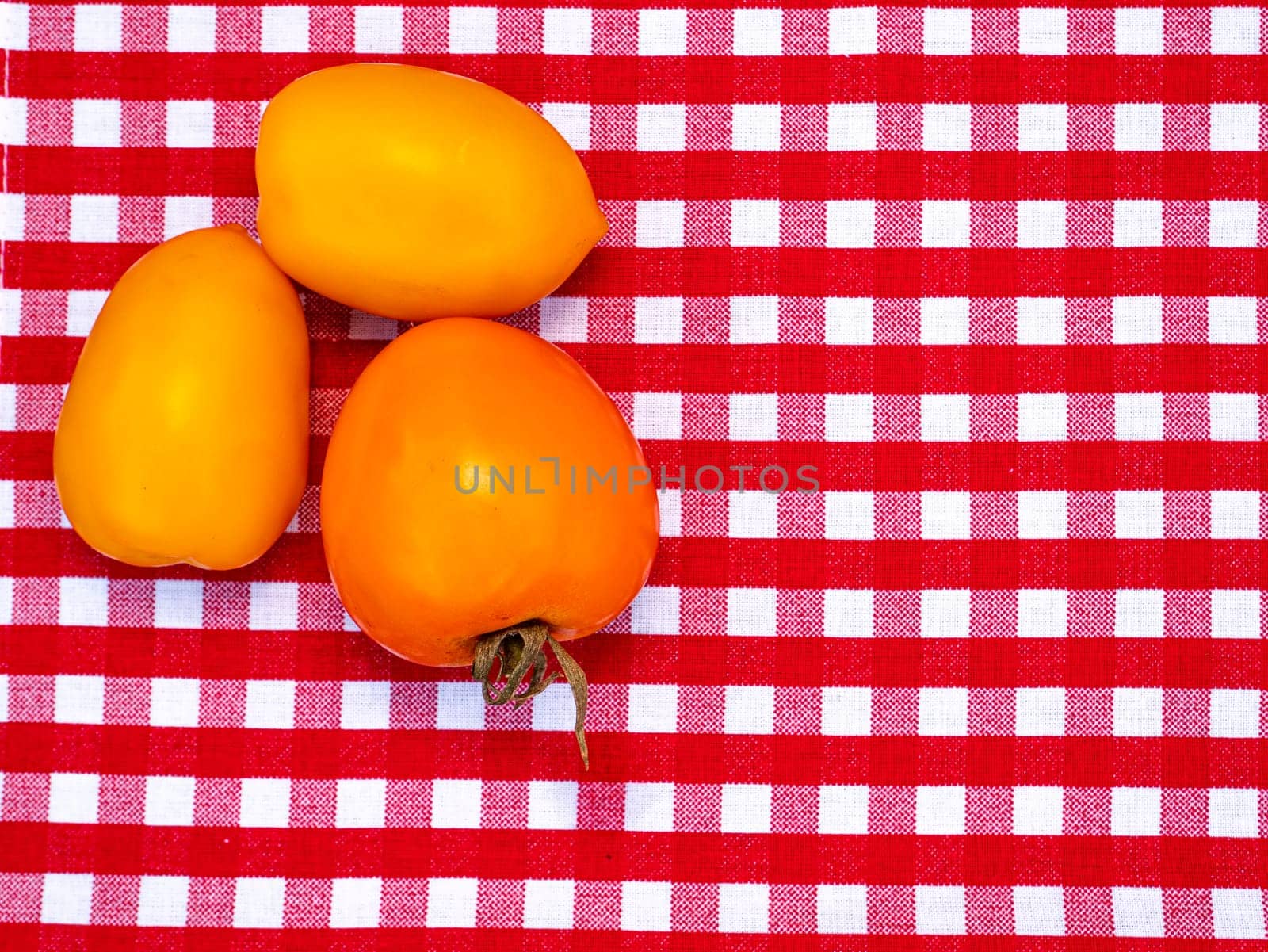 Yellow tomato vegetables on the kitchen table. Food photo. Harvesting tomato. Advertising photo of a shop window of a vegetable store. Agriculture. Farming activities. Place for text.