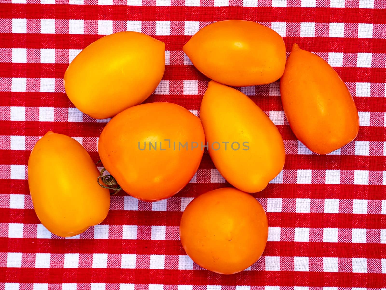 Yellow tomato vegetables on the kitchen table. Food photo. Harvesting tomato. Advertising photo of a shop window of a vegetable store. Agriculture. Farming activities. Place for text.
