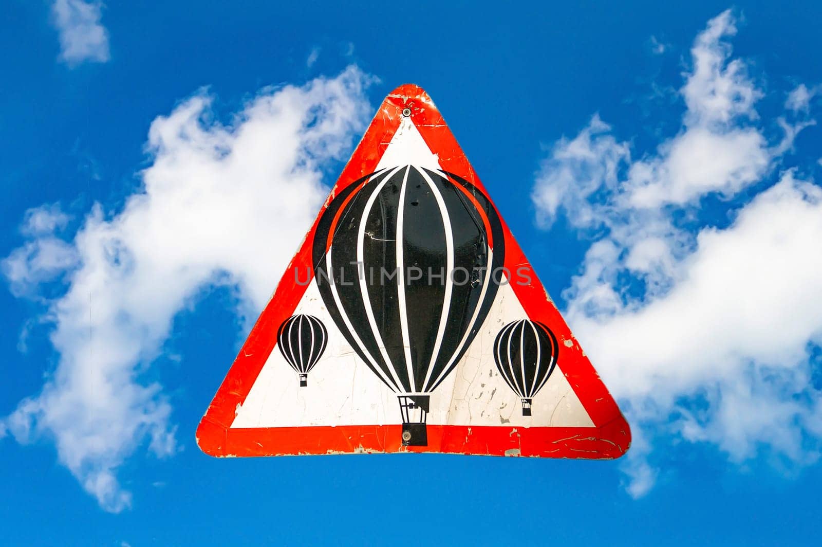 Sign warning about flights of balloons in the sky. Balloons with a basket. Warning sign. Blue sky. White clouds. Air flight rules. Background image. Aircraft warning sign.