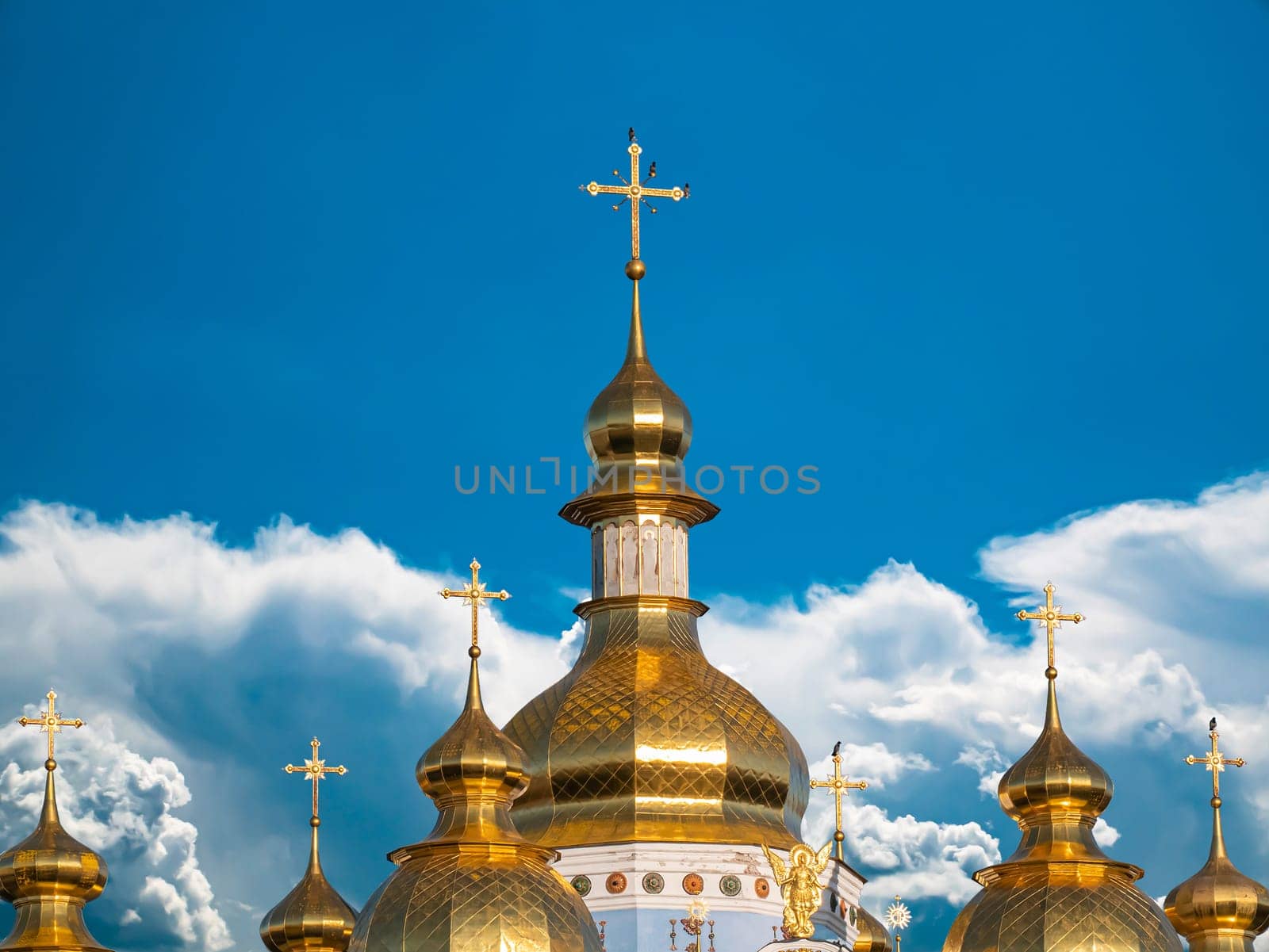 Domes with a cross of a Christian church. Christian cross. Religion and culture. Orthodox church. Blue sky. White clouds. Merry Christmas. Easter holidays. Background image.