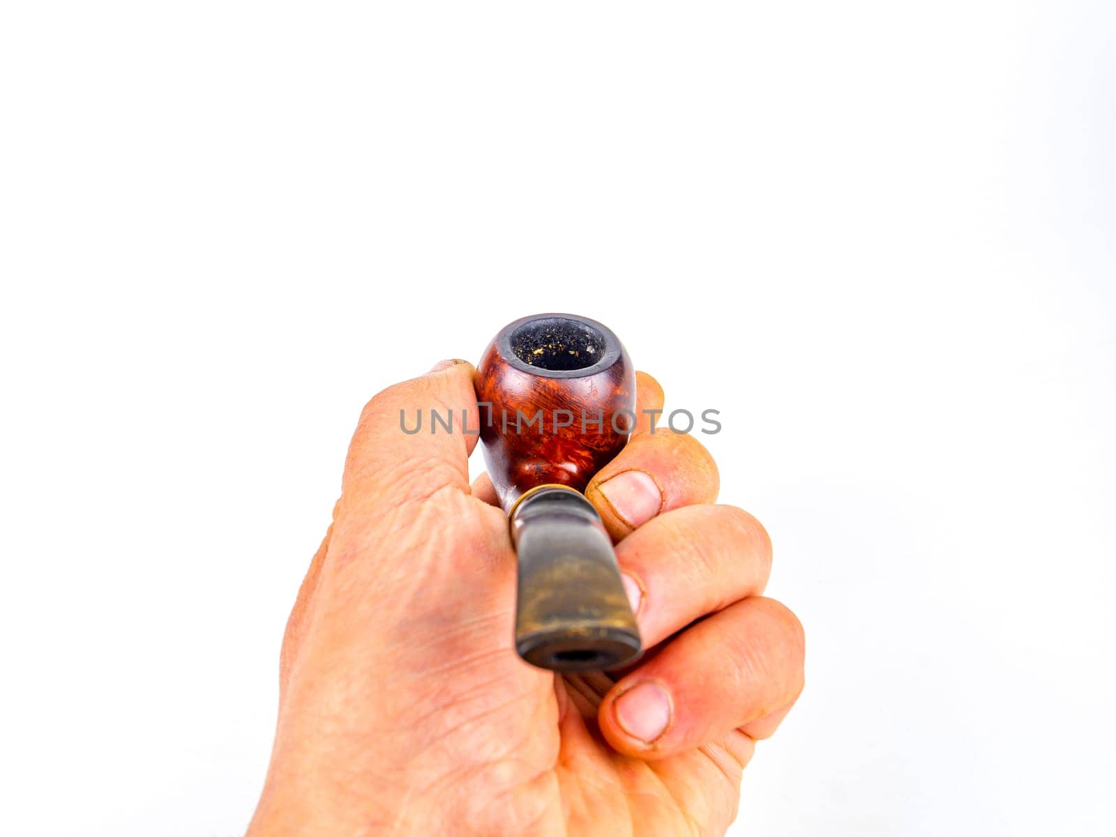 Pipe for smoking tobacco in the hand of a smoker on a white background. Wooden pipe for smoking. Tobacco products. Smokers tool. Human hand. Smoker addiction. Nicotine.