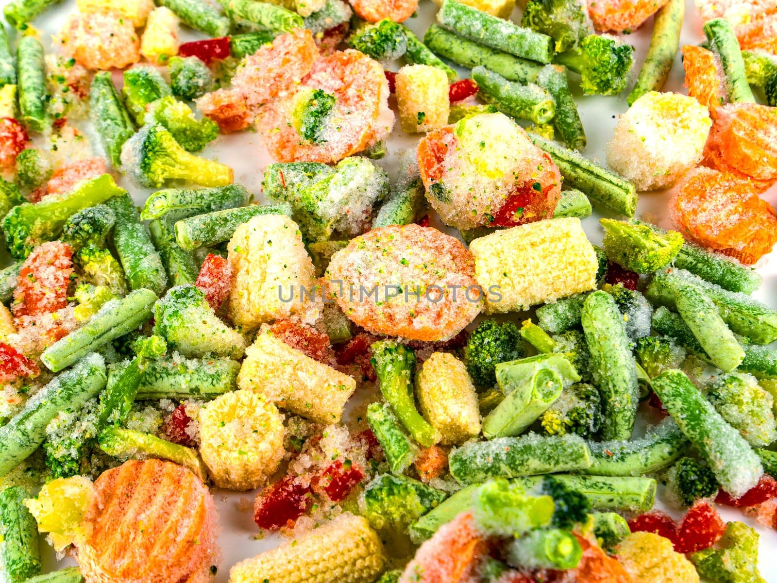 Fresh frozen vegetables on a white plate. Freezing vegetables and fruits. Freshly frozen foods. Vegetable in the freezer. Storing a vegetable in the refrigerator. Freezing vitamin. Vegetarianism.