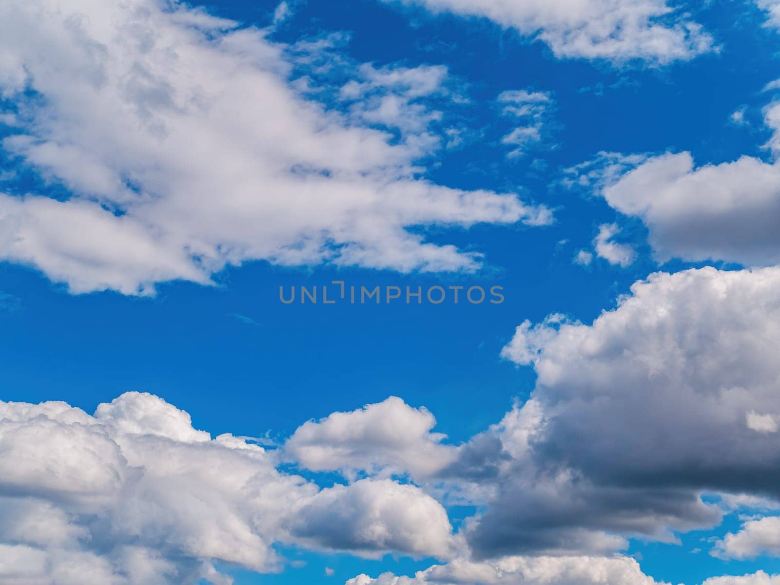 White cloud against blue sky in sunlight. White cumulus clouds. Blue sky. Sunlight. Cloudy horizon. Natural background. Atmosphere and stratosphere. Weather forecast. Space. Air flight.