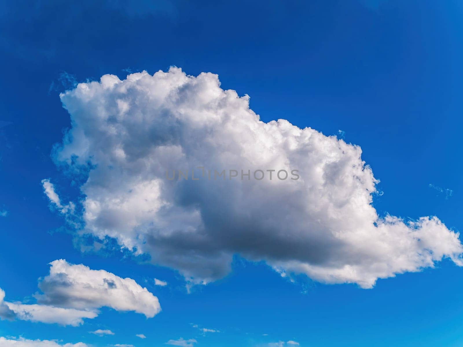 White cloud against blue sky in sunlight. White cumulus clouds. Blue sky. Sunlight. Cloudy horizon. Natural background. Atmosphere and stratosphere. Weather forecast. Space. Air flight.