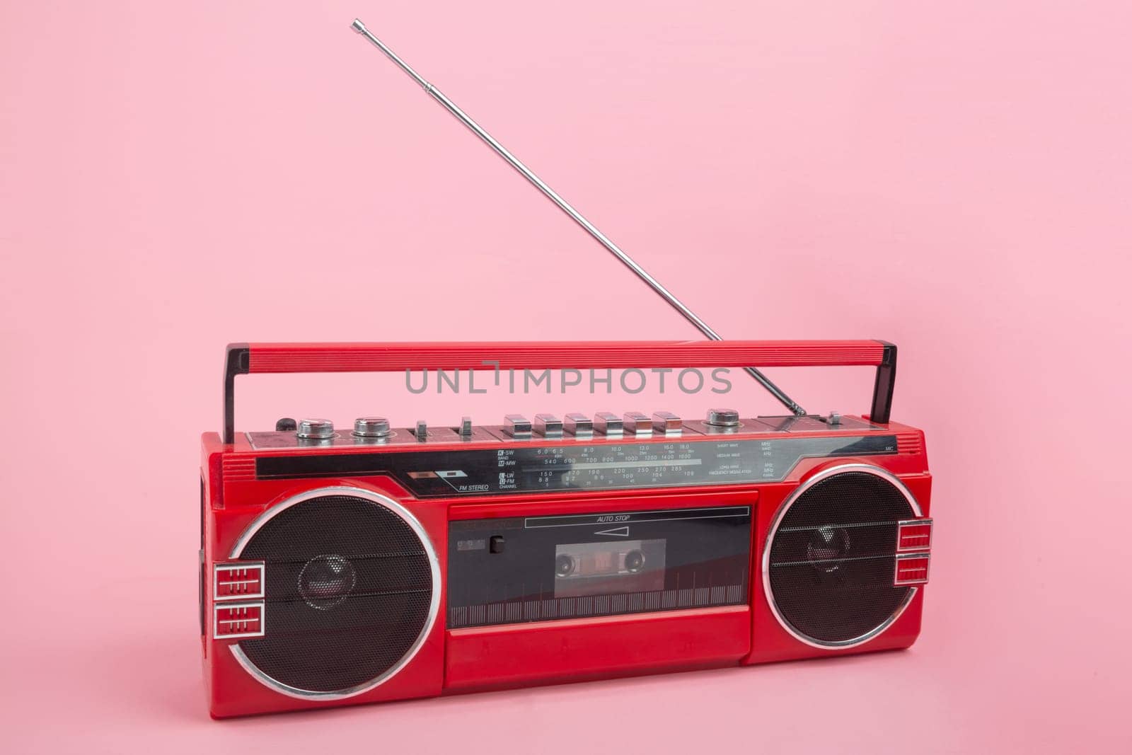 Cassette recorder with opened antenna on pink background