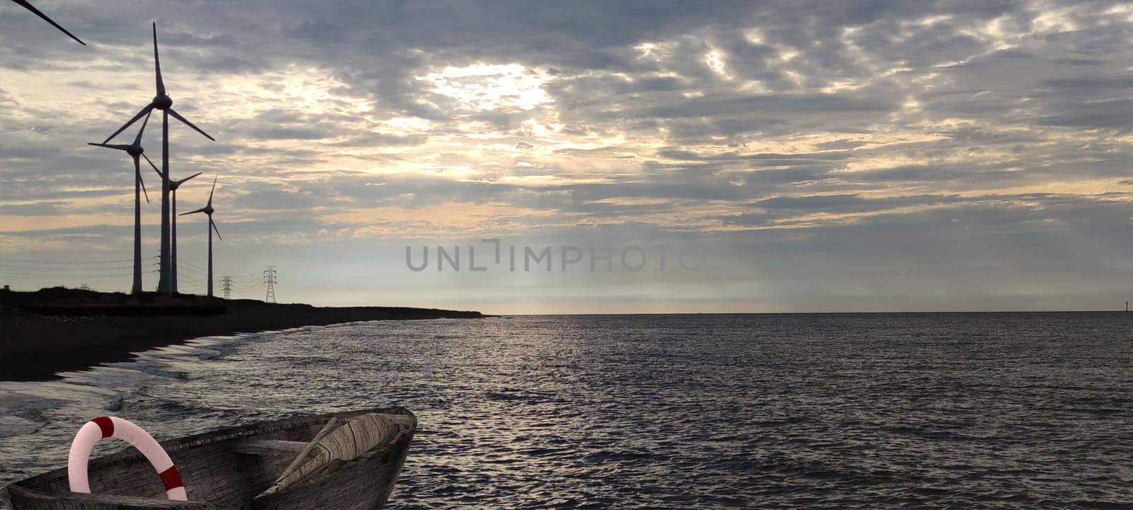 The windmill on the beach and traditional wood made boat