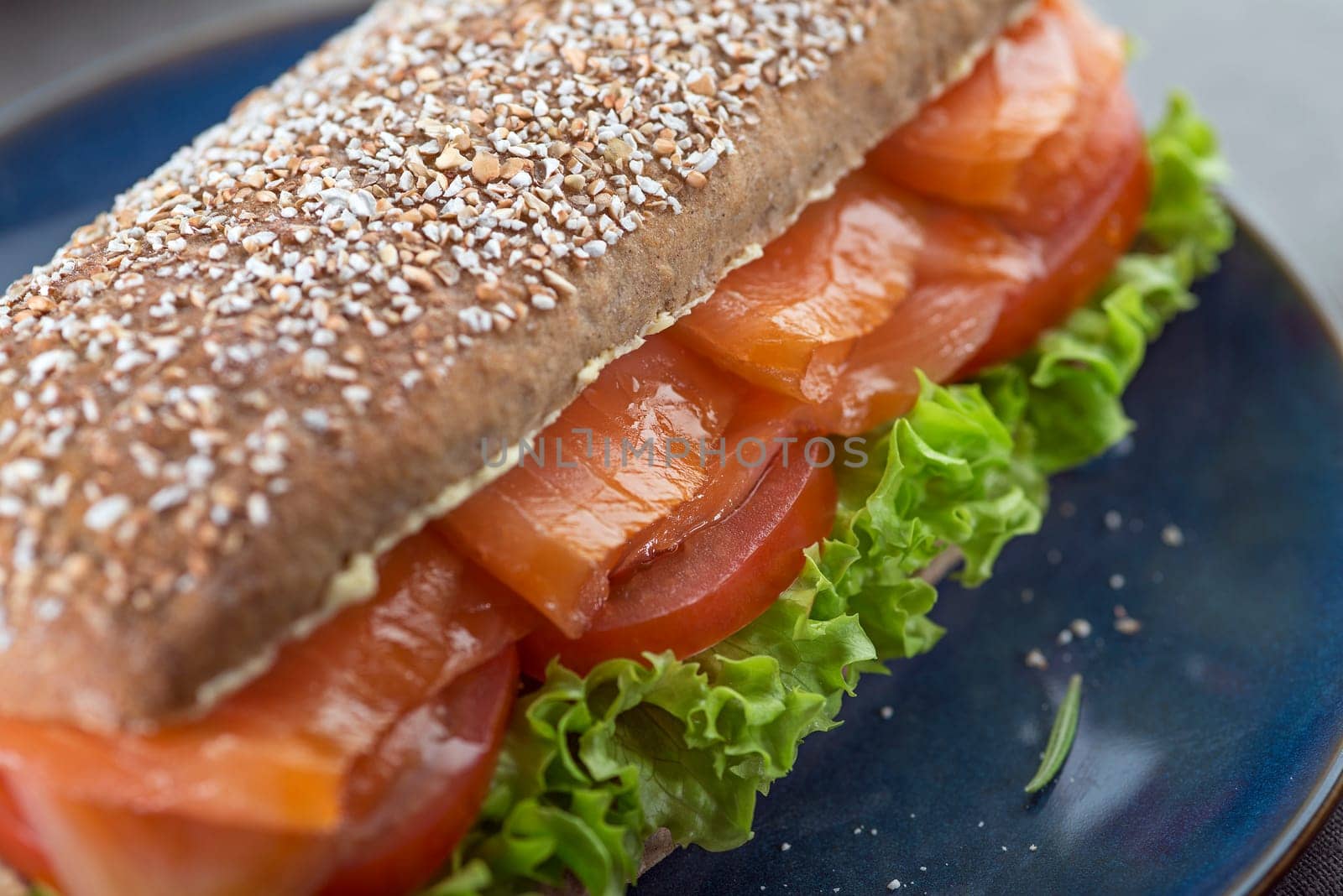 Sandwich with smoked salmon salad and tomato close up. Healthy food