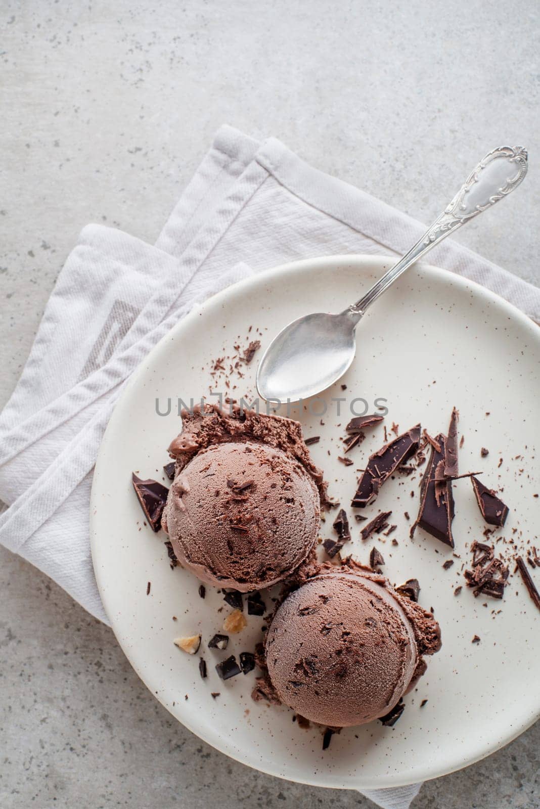 Fresh chocolate ice cream scoops in a plate with spoon