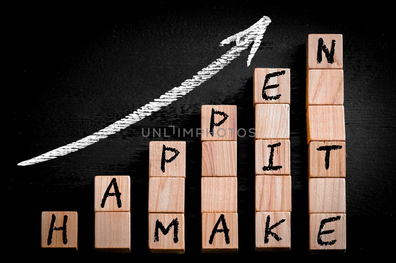 Message MAKE IT HAPPEN  on ascending arrow above bar graph of Wooden small cubes isolated on black background. Chalk drawing on blackboard. Business Concept image.