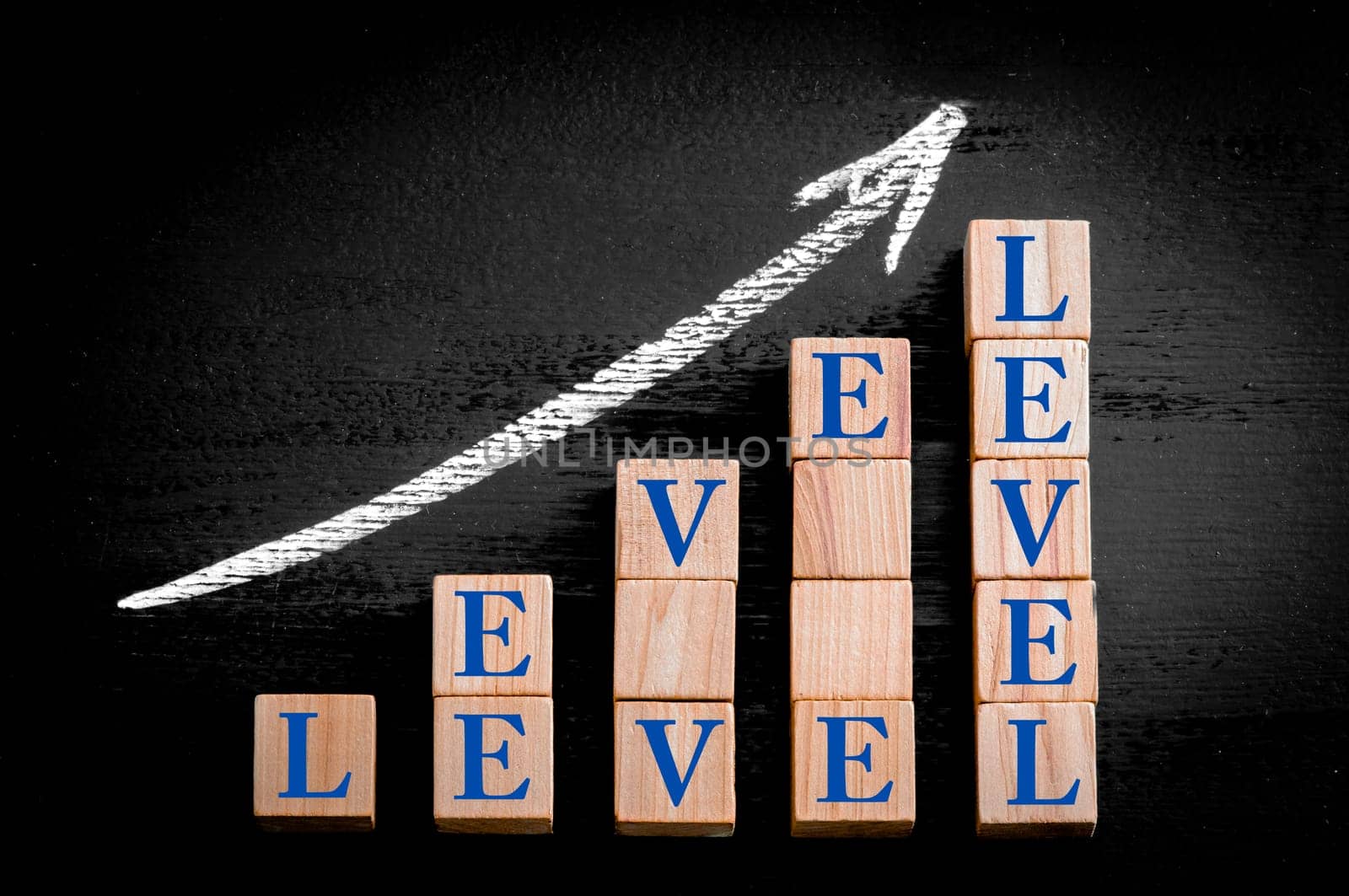 Ascending arrow above bar graph of Wooden small cubes isolated on black background. Chalk drawing on blackboard. Business Concept image.