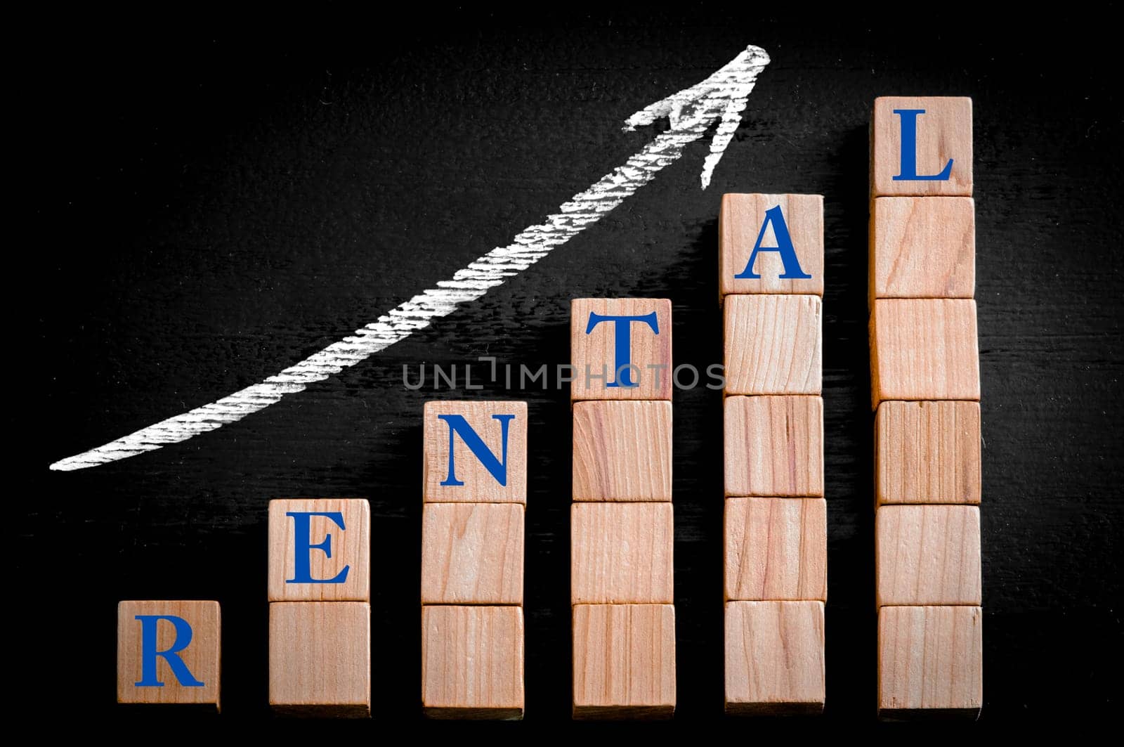 Word RENTAL on ascending arrow above bar graph of Wooden small cubes isolated on black background. Chalk drawing on blackboard. Business Concept image.
