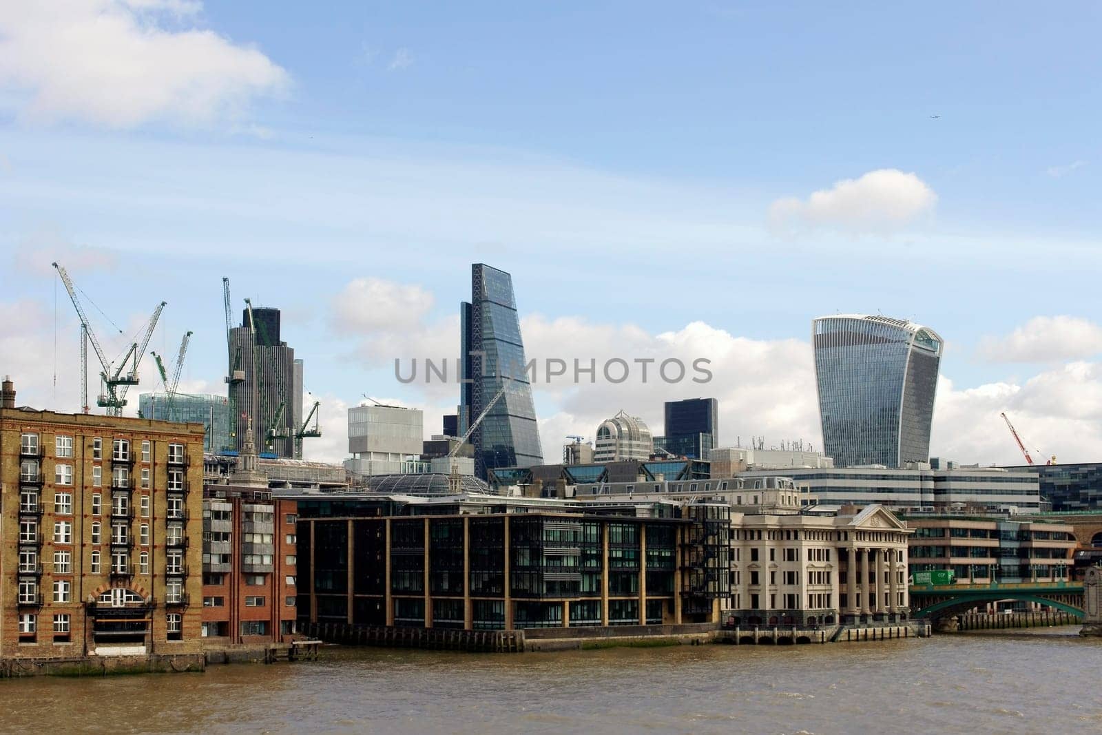 London,United Kingdom – March 31,2015: The skyline of the City of London office complex behind residential buildings and historic buildings on the banks of the Thames on 31 March 2015 in London.