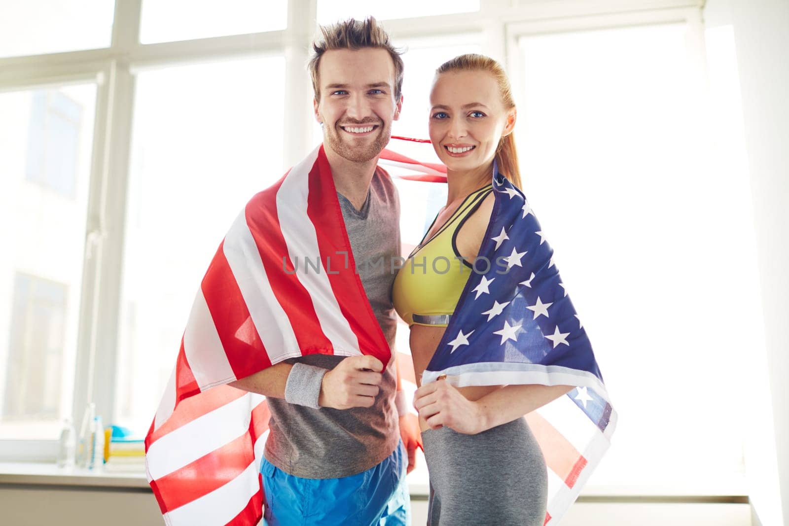 Young sporty couple wrapped in USA flag