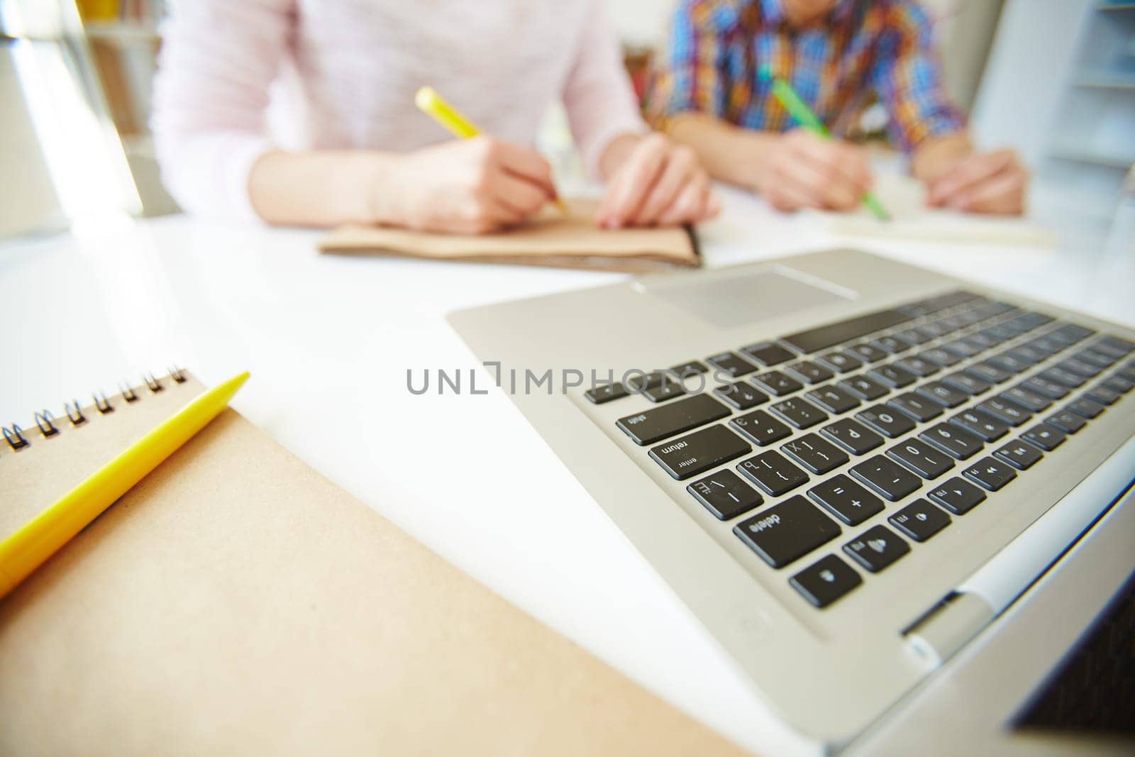Laptop keypad and notepad with pen at workplace