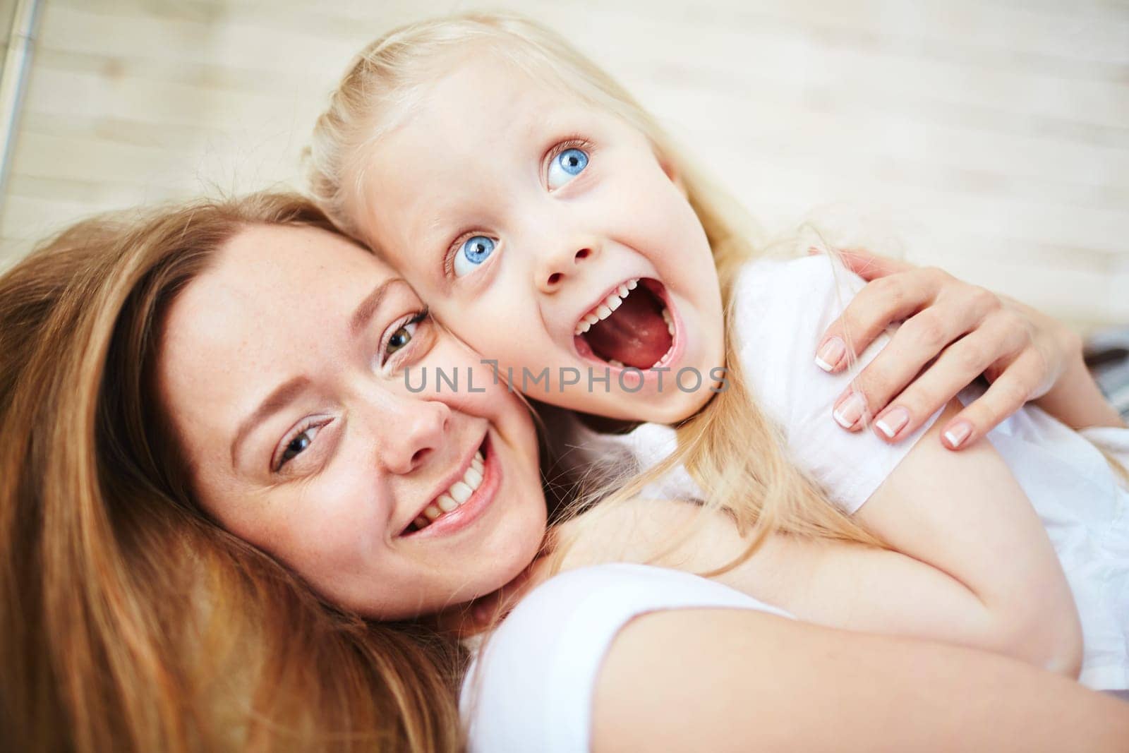 Affectionate female embracing her amazed little daughter