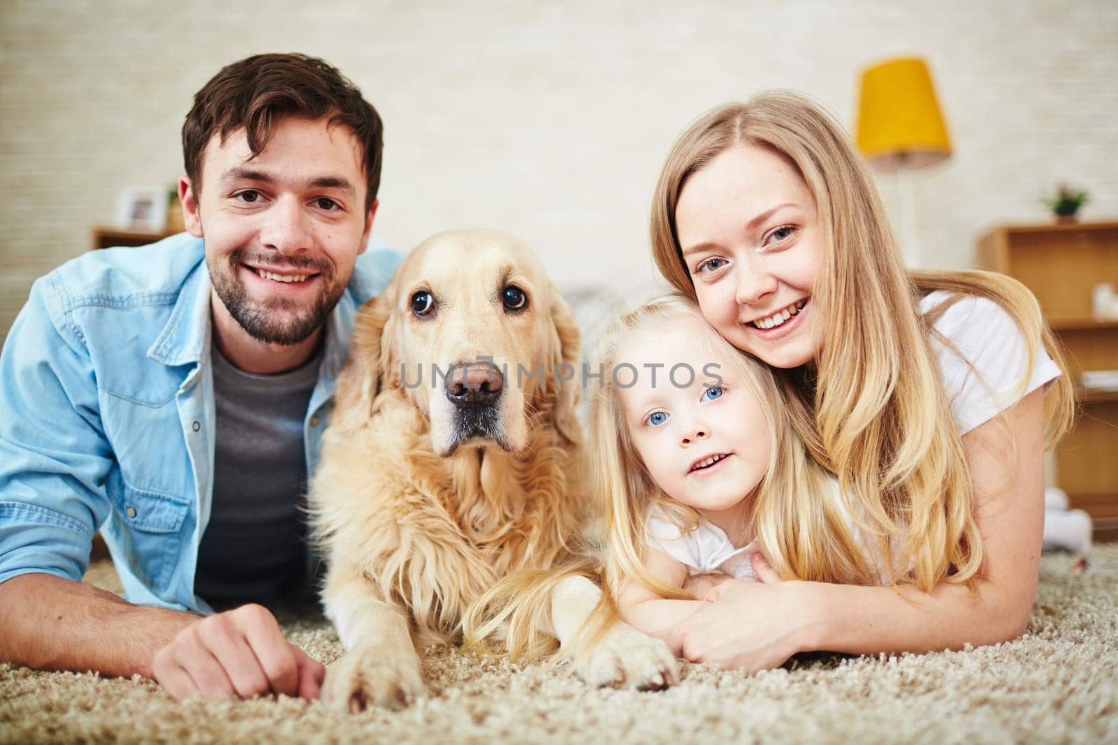 Happy young couple, their daughter and dog