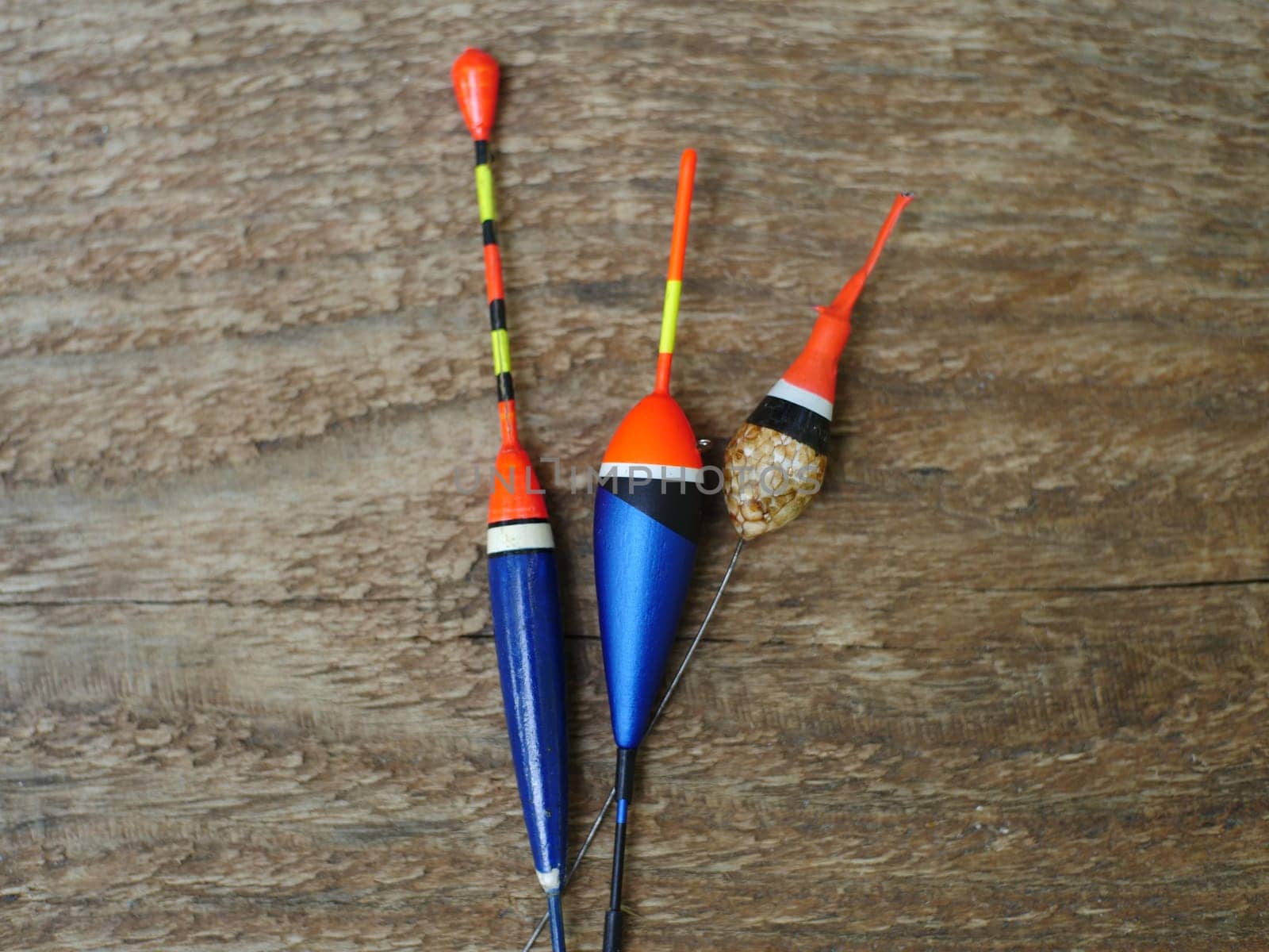 three fishing bobbers on wooden background close to still life