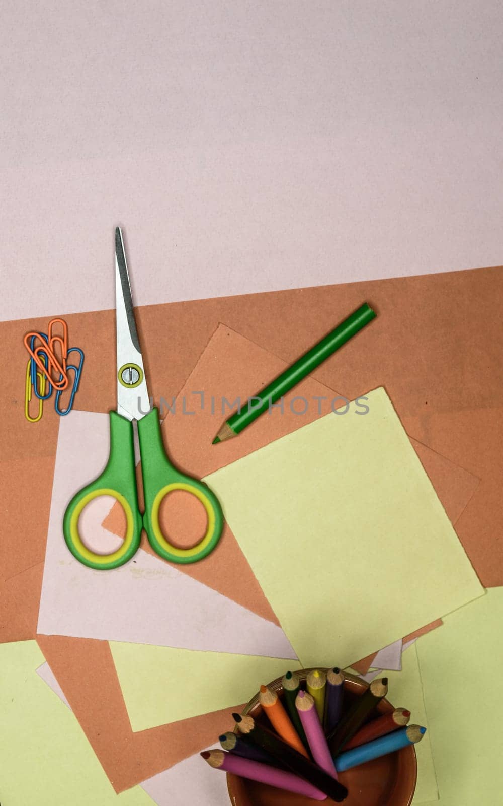 Colour paper, scissors, school stationery supplies, pencils, paint, and ruler lying on table. Origami DIY tutorial for kids background. Back to school concept. Directly above. Flat lay.