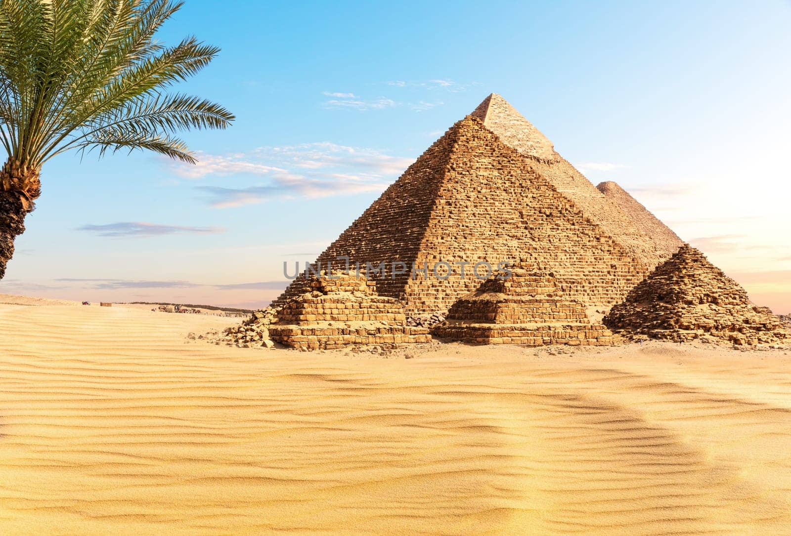 Pyramids of Egypt at sunset in the sunny desert of Giza, famous Wonder of the World.