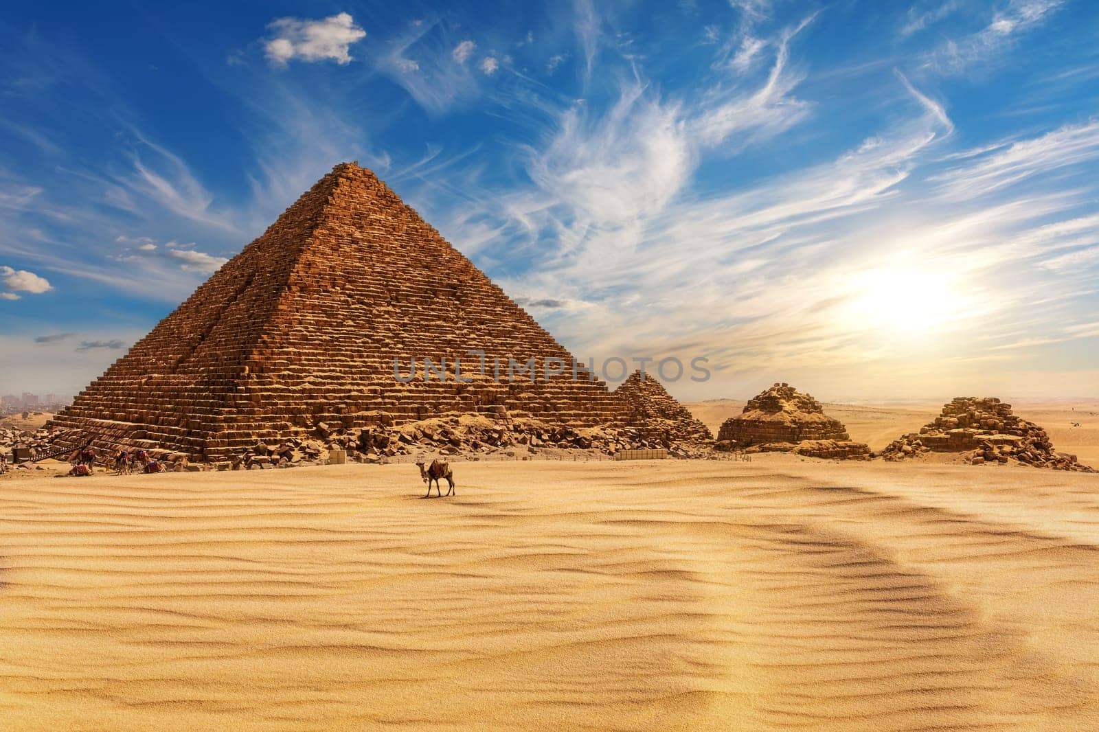 The Pyramid of Menkaure at sunset in Egypt and a camel nearby, Giza.