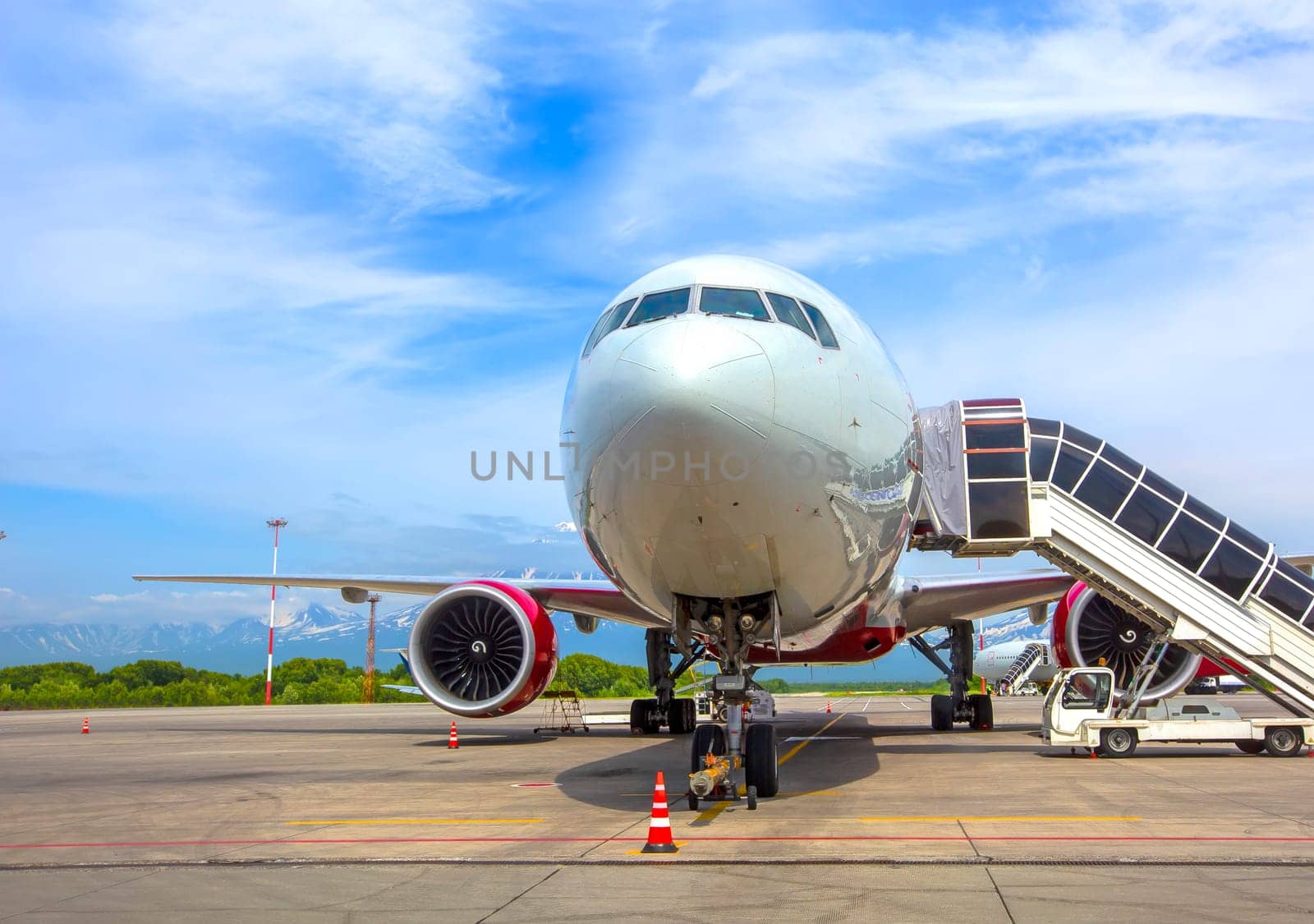 The Airplane with a passenger boarding steps on the airport apron