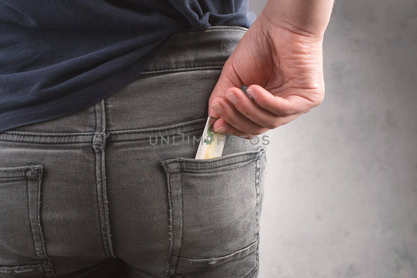Putting an Euro bill into a jeans pocket, teenager, male