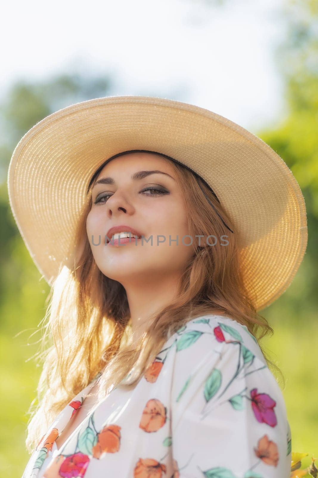 Beautiful young woman in summer hat posing and looking at the camera. Vertically.