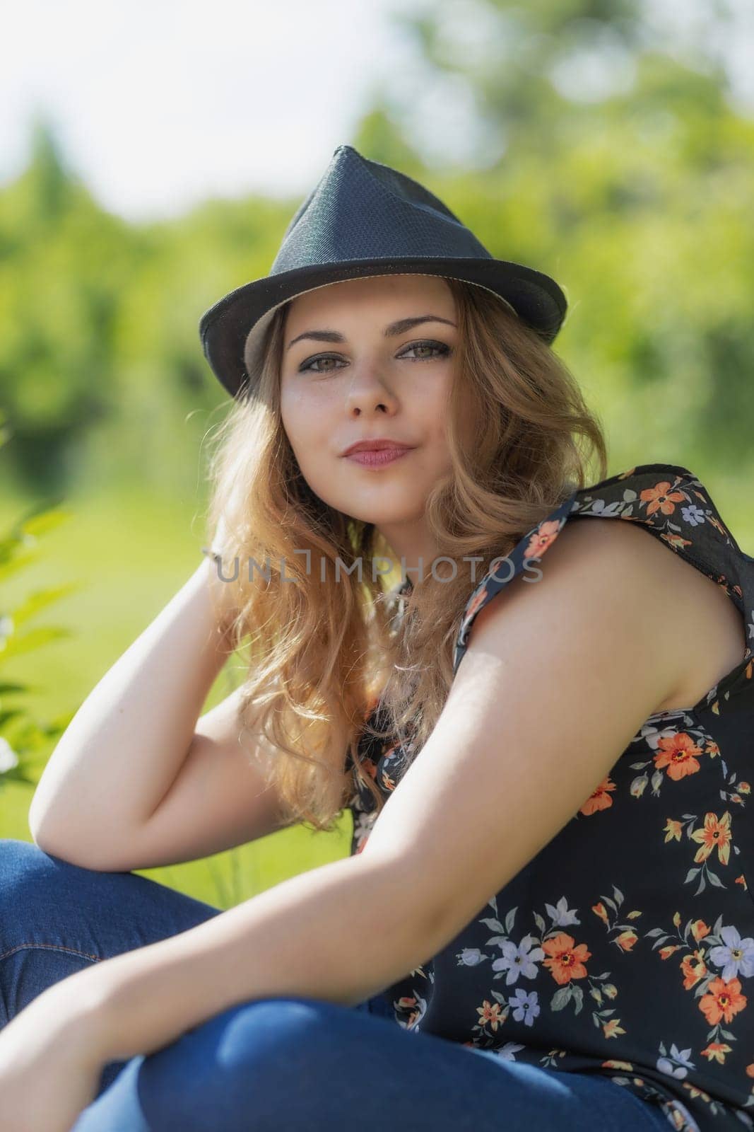 Portrait of beautiful young woman posing in black hat looking at the camera. Vertically.