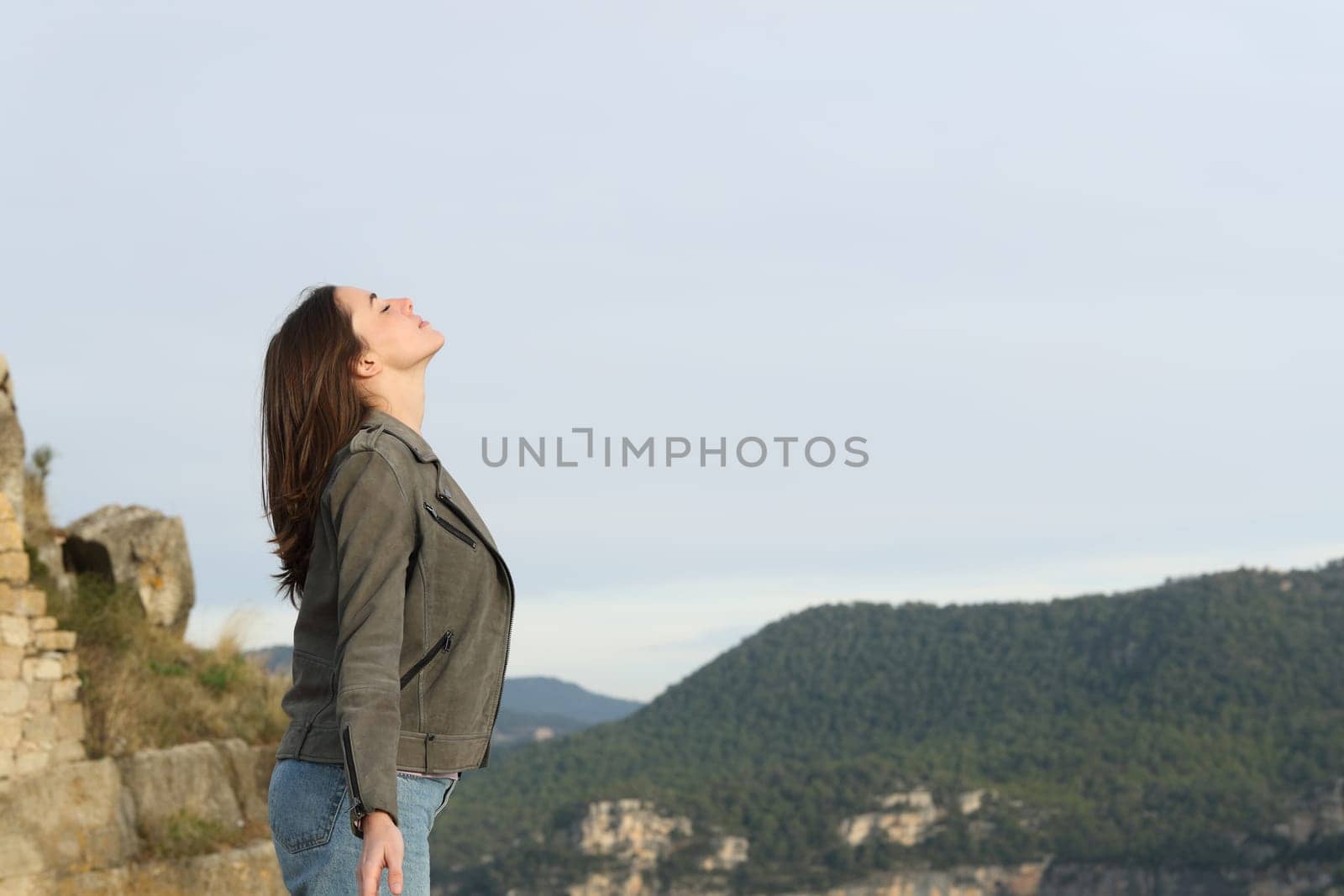 Profile of a casual woman breathing fresh air in the mountain