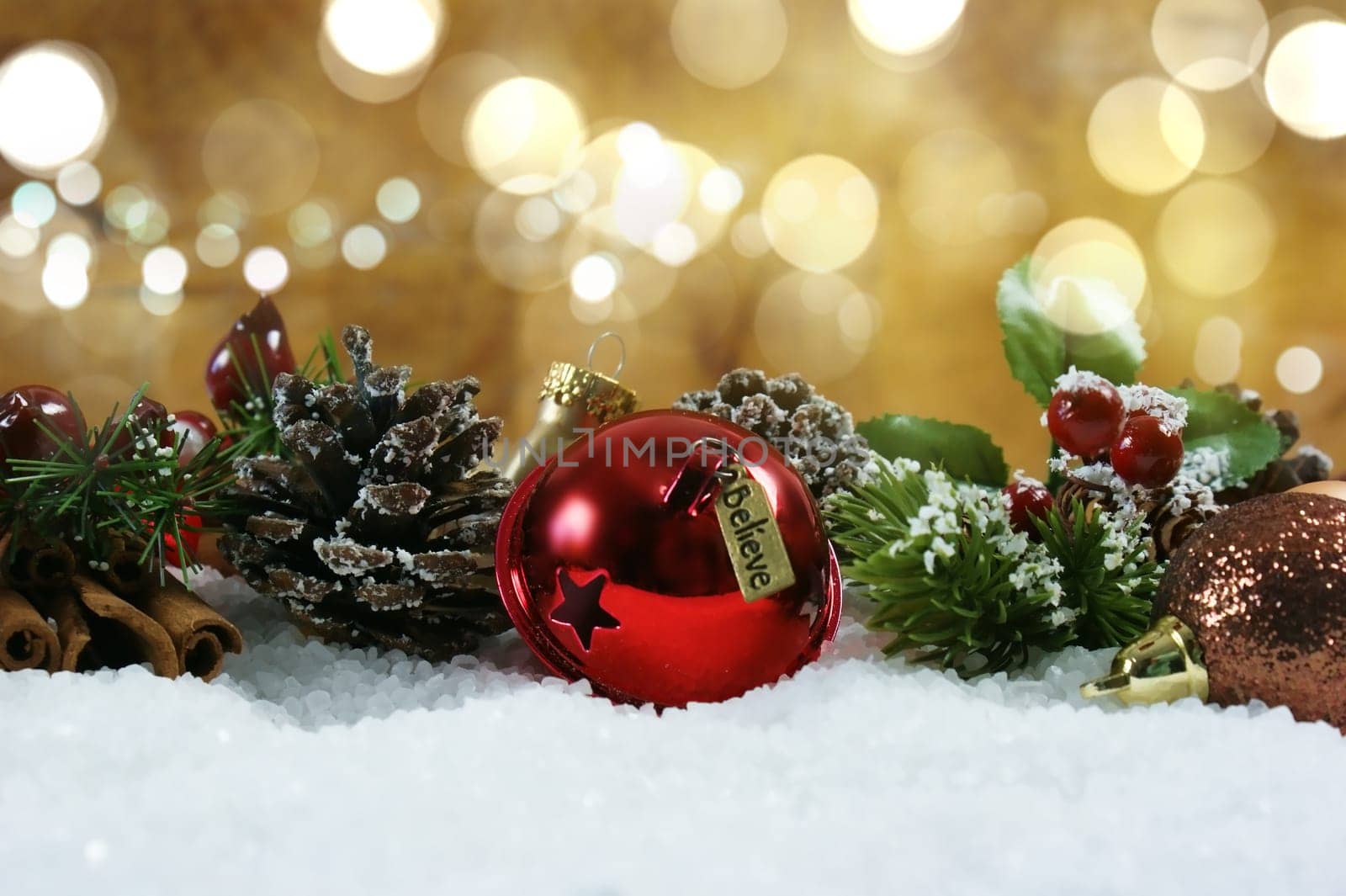 Christmas bell with tag saying believe nestled in snow