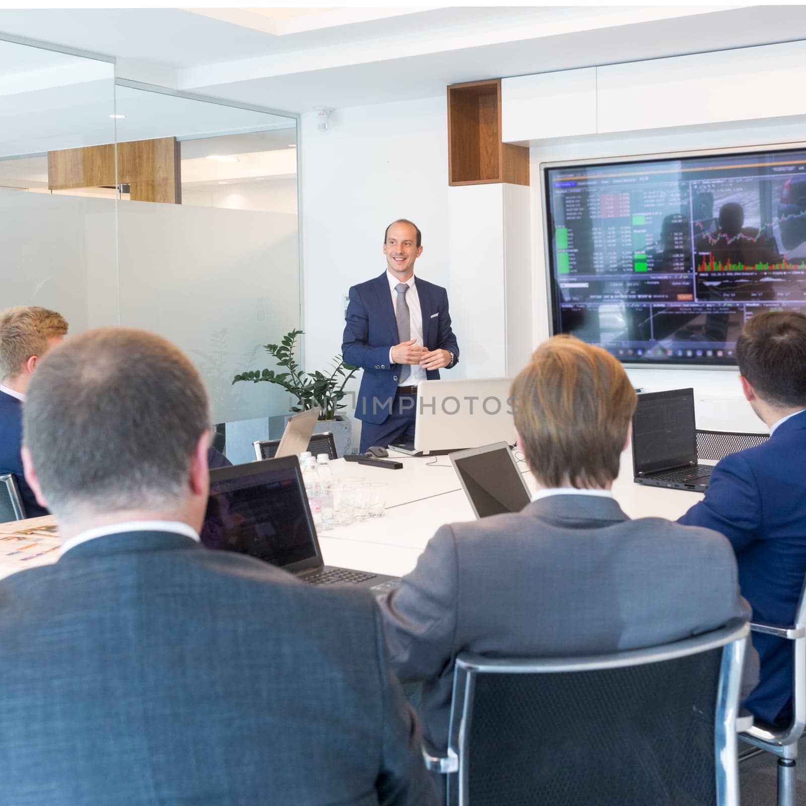 Business man making a presentation at office. Business executive delivering a presentation to his colleagues during meeting or in-house business training, explaining business plans to his employees.