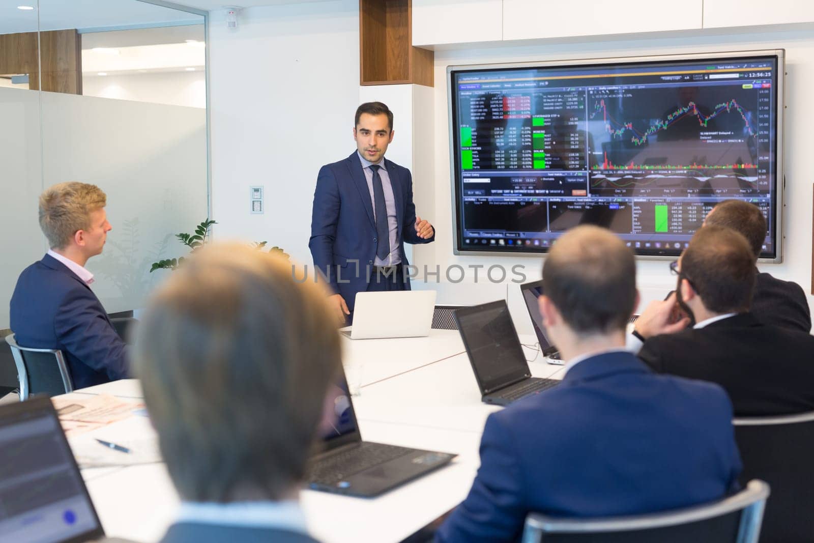 Business man making a presentation at office. Business executive delivering a presentation to his colleagues during meeting or in-house business training, explaining business plans to his employees.