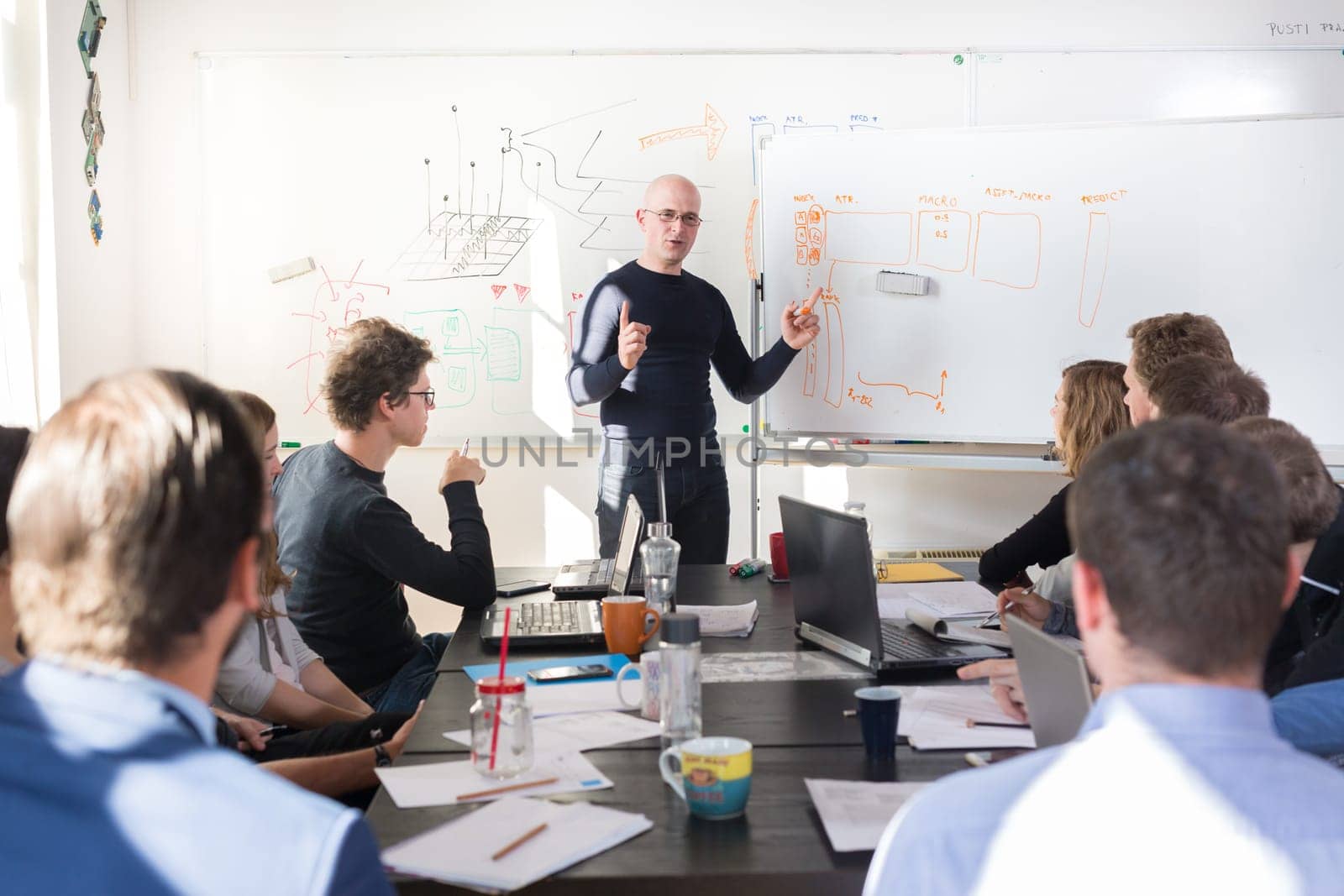 Relaxed informal IT business startup company meeting. Team leader discussing and brainstorming new approaches and ideas with colleagues. Startup business and entrepreneurship concept.