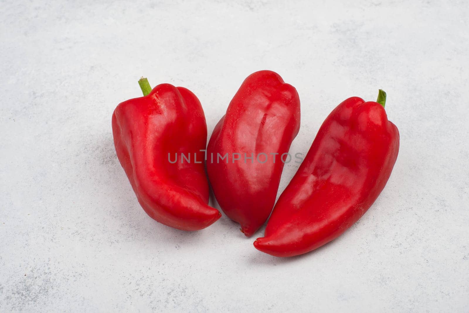 Fresh red paprika isolated on a white textured background, empty copy space for text