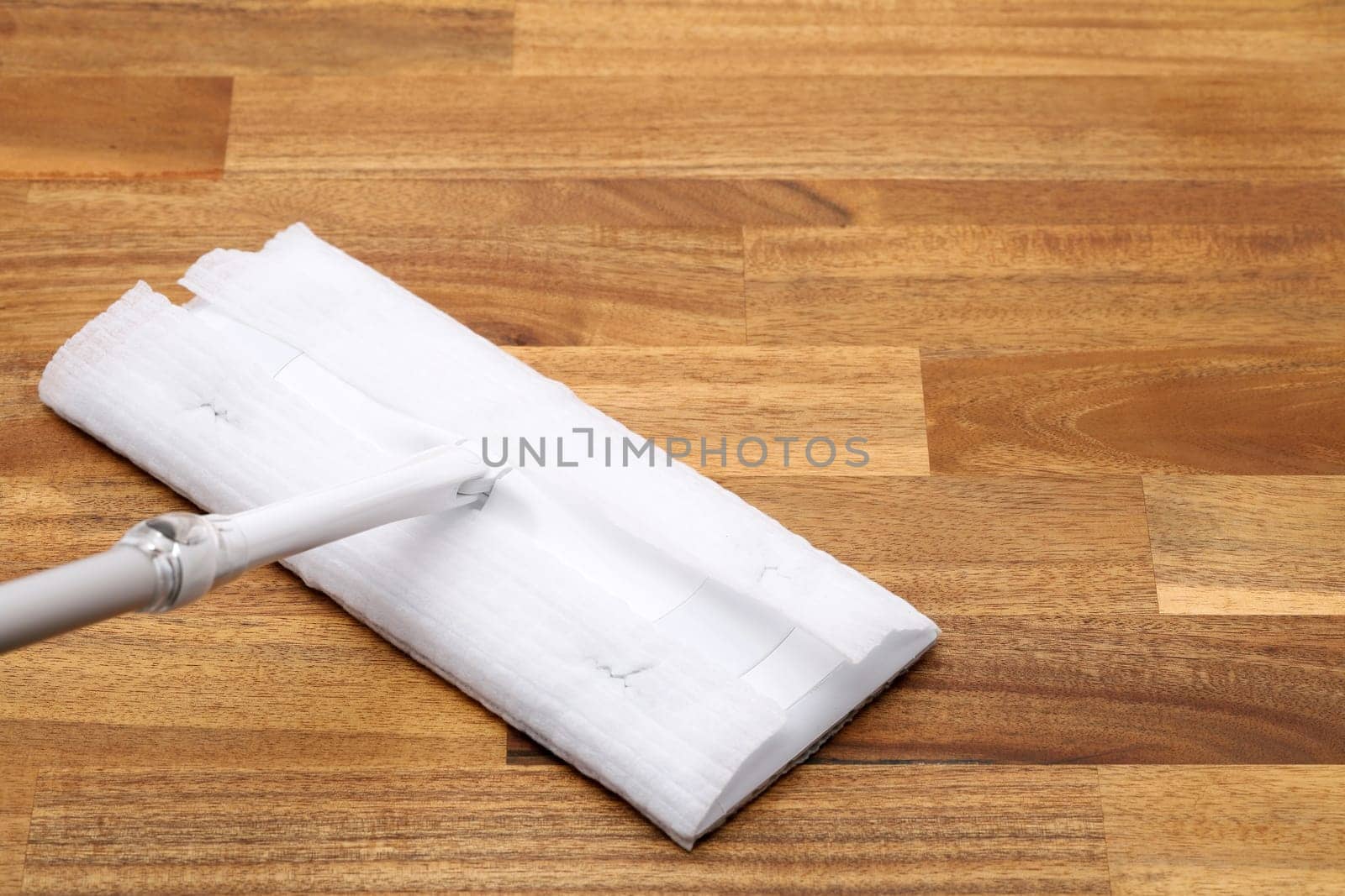 Part of flat wet paper mop and disposable working head on wooed floor