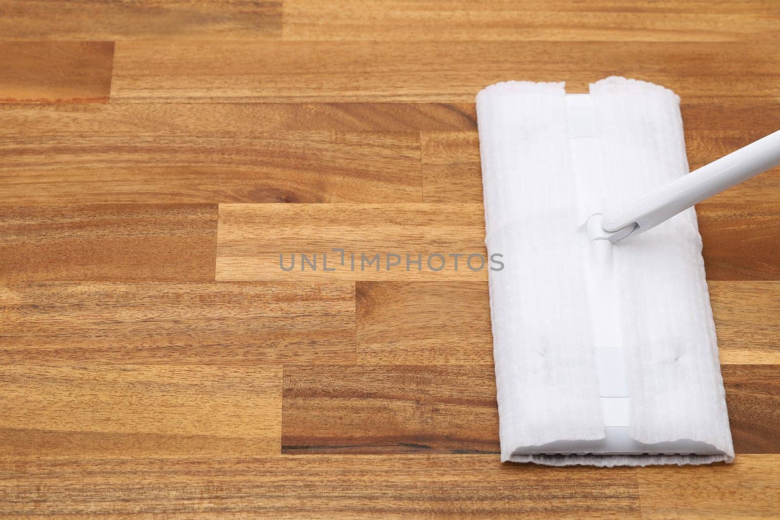 Part of flat wet paper mop and disposable working head on wooed floor