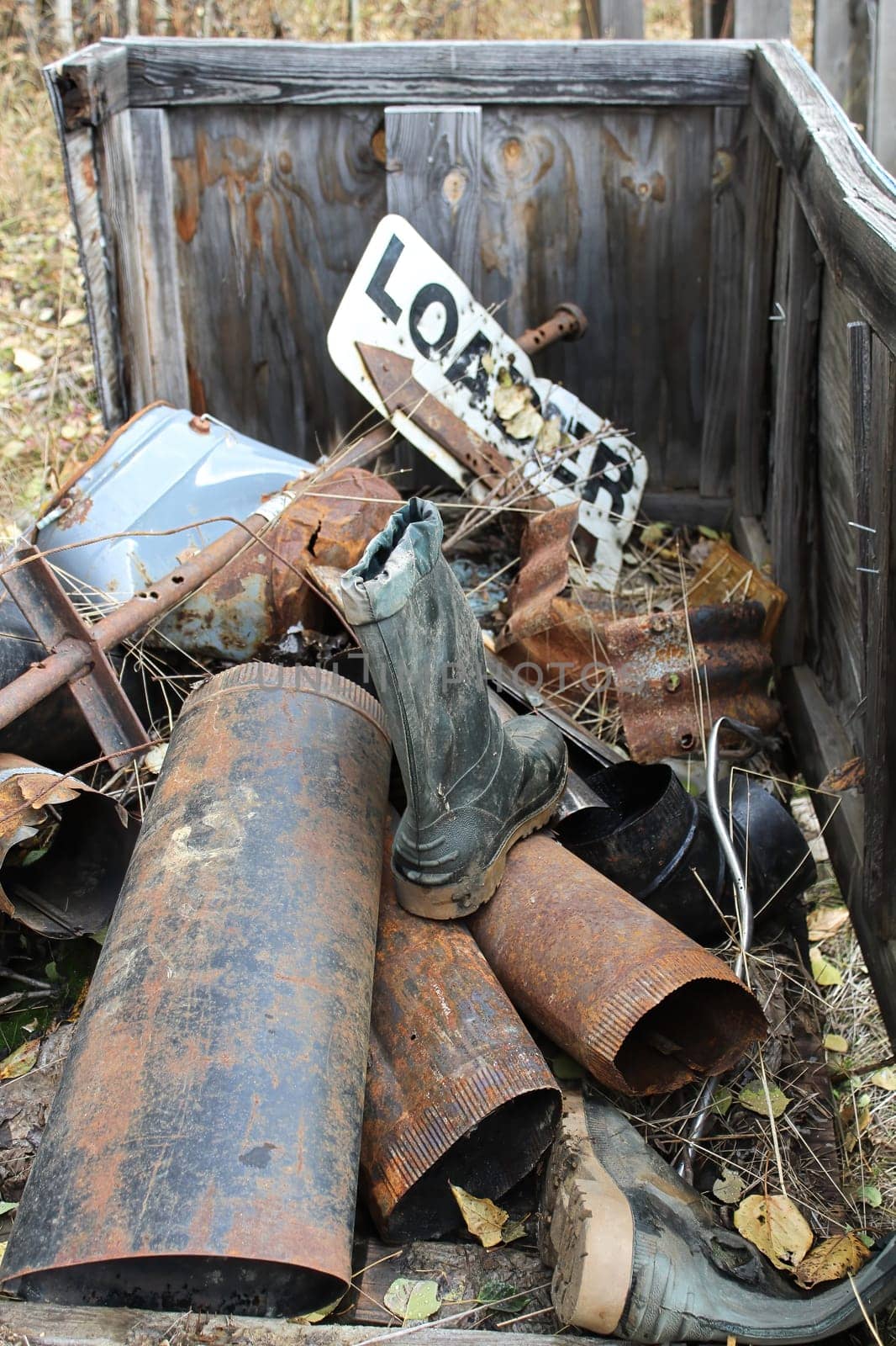 Vertical closeup of a pile of rusty metal and rubber boots.