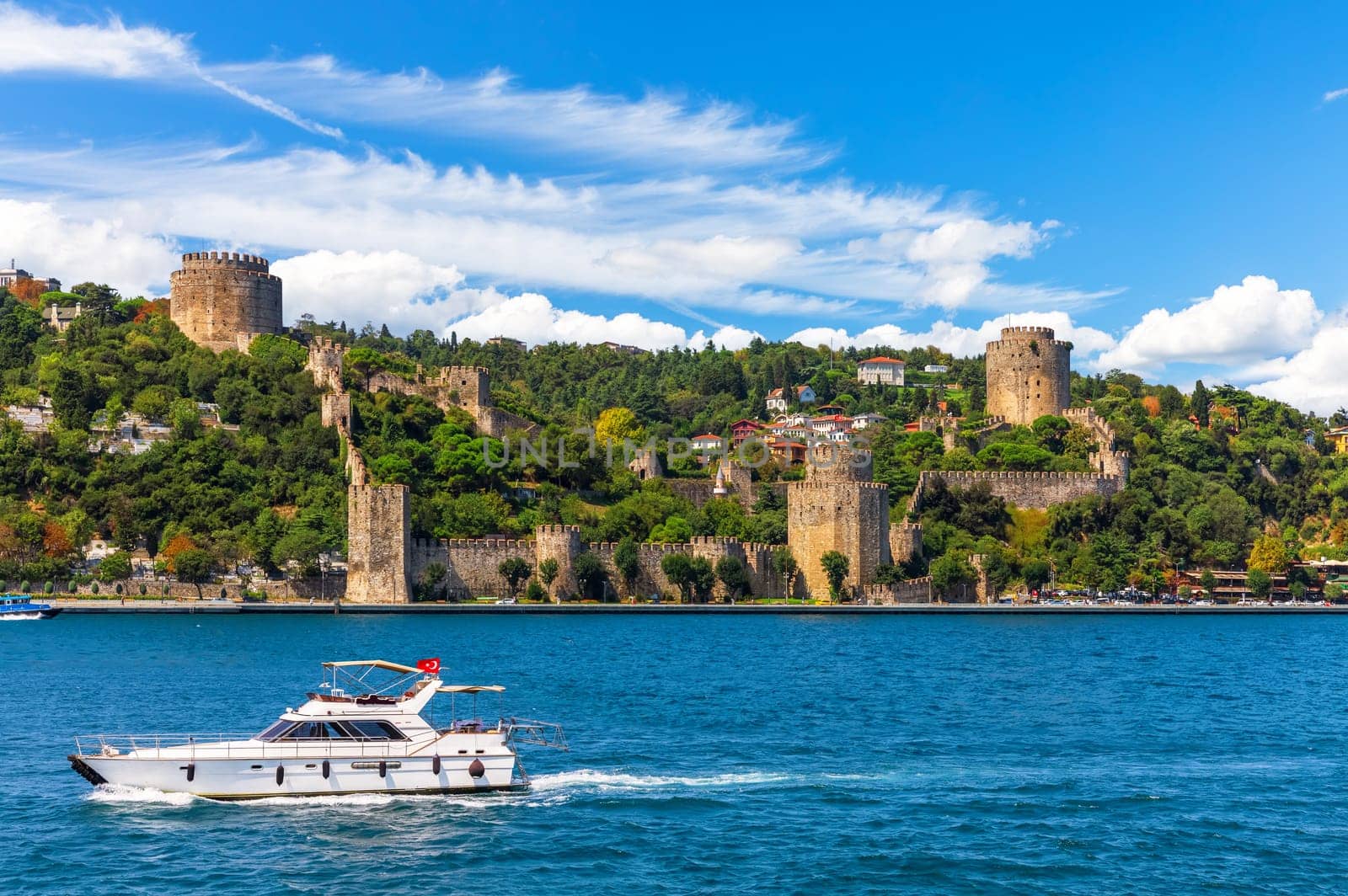 The ship sails in the Bosphorus strait by Rumeli Hisari castle, Istanbul.