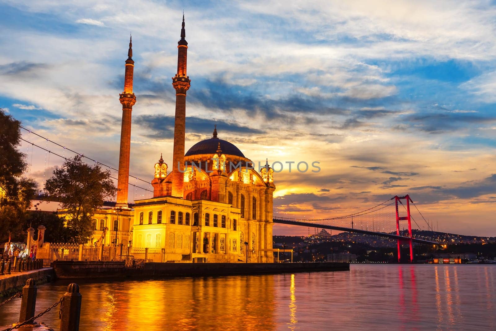 A Grand Imperial Mosque of Istanbul and the Bosphorus bridge in the night lights.