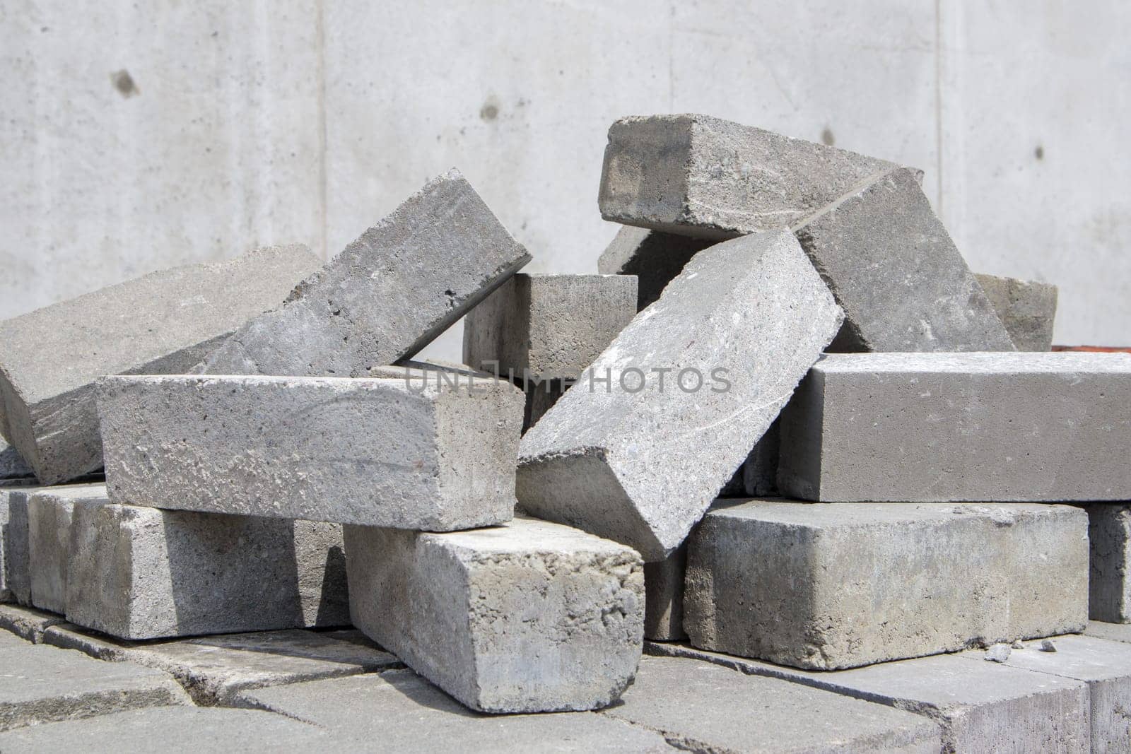 A pile of cement type bricks. Solid brick is used for construction. Lots of loose concrete bricks at the construction site