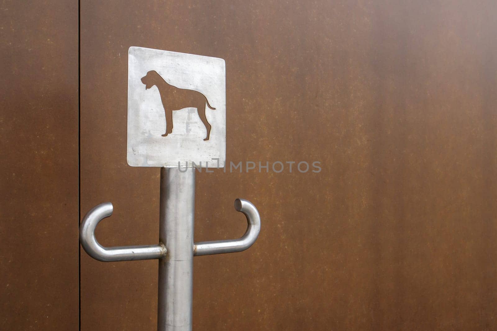 Close-up of an outdoor dog parking sign. A place for a leash for dogs waiting for their owners on the street. Attach a leash, in public places or at the entrance to the store. Copy space