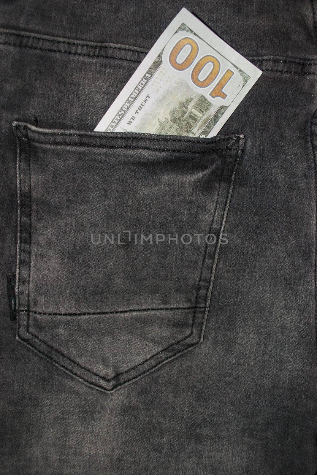 Many hundred dollar bills in jeans pocket. US dollars are visible in your pocket