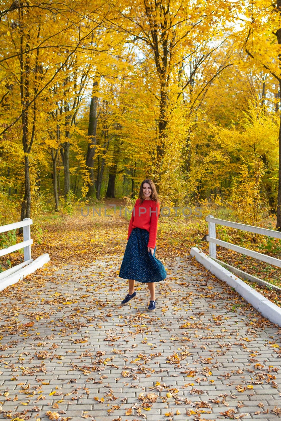 Beautiful park. Golden autumn. The girl is spinning on the track near a beautiful park